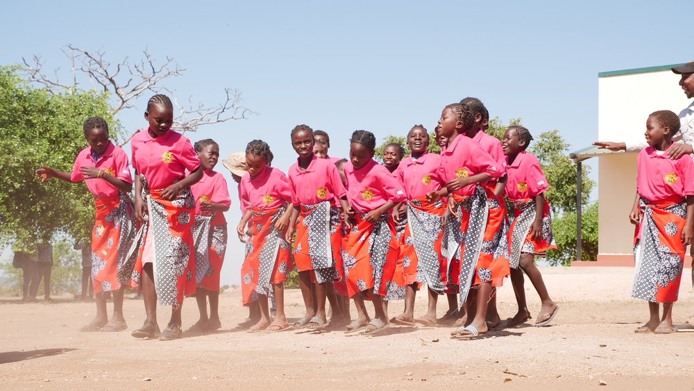 Young girls dance outside a classroom paid for by Gorongosa National Park in the buffer zone surrounding the park in Sofala province, Mozambique, May 24, 2022