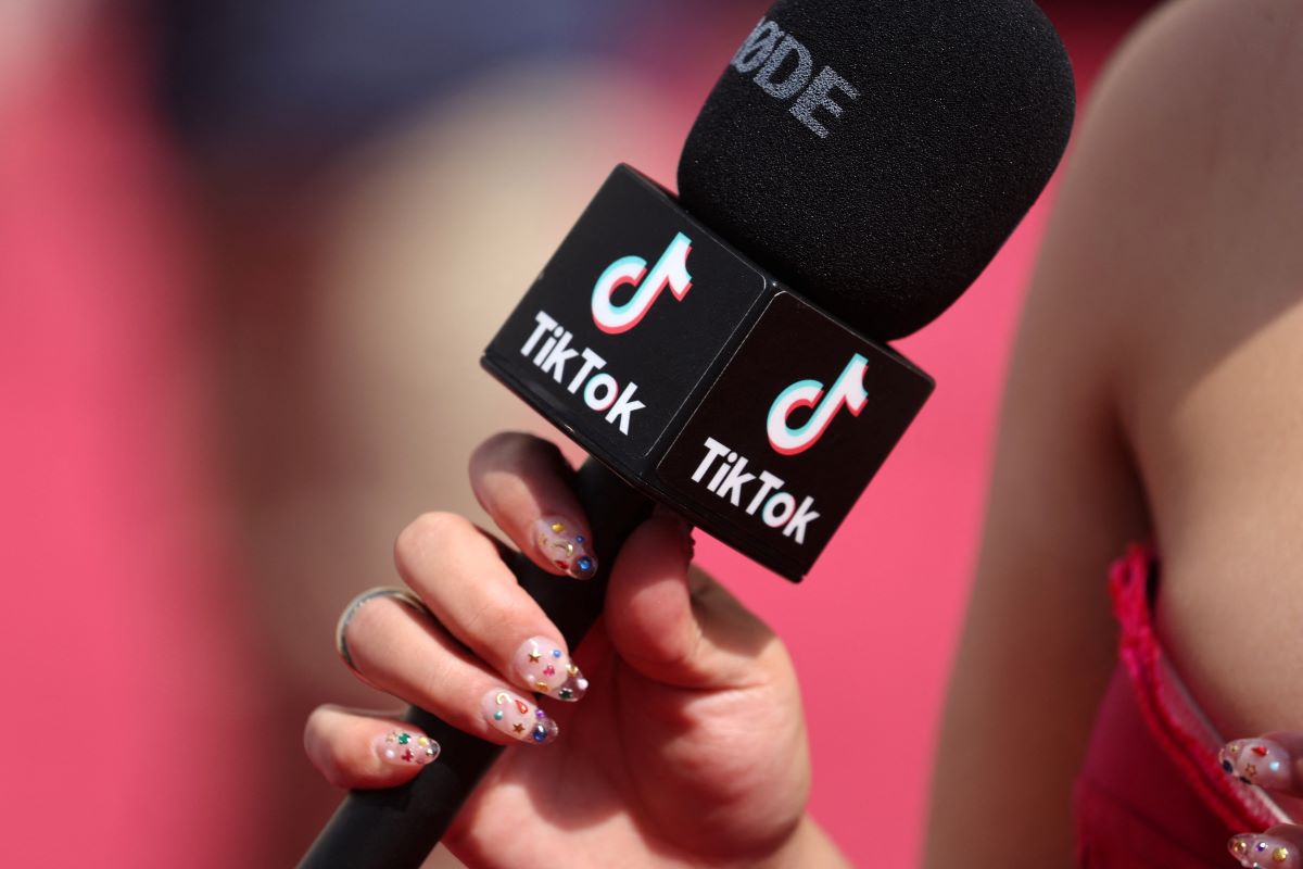 A social influencer talks into a TikTok microphone on the red carpet during the Oscars arrivals at the 94th Academy Awards in Hollywood, Los Angeles, California, U.S., March 27, 2022. REUTERS/Mike Blake