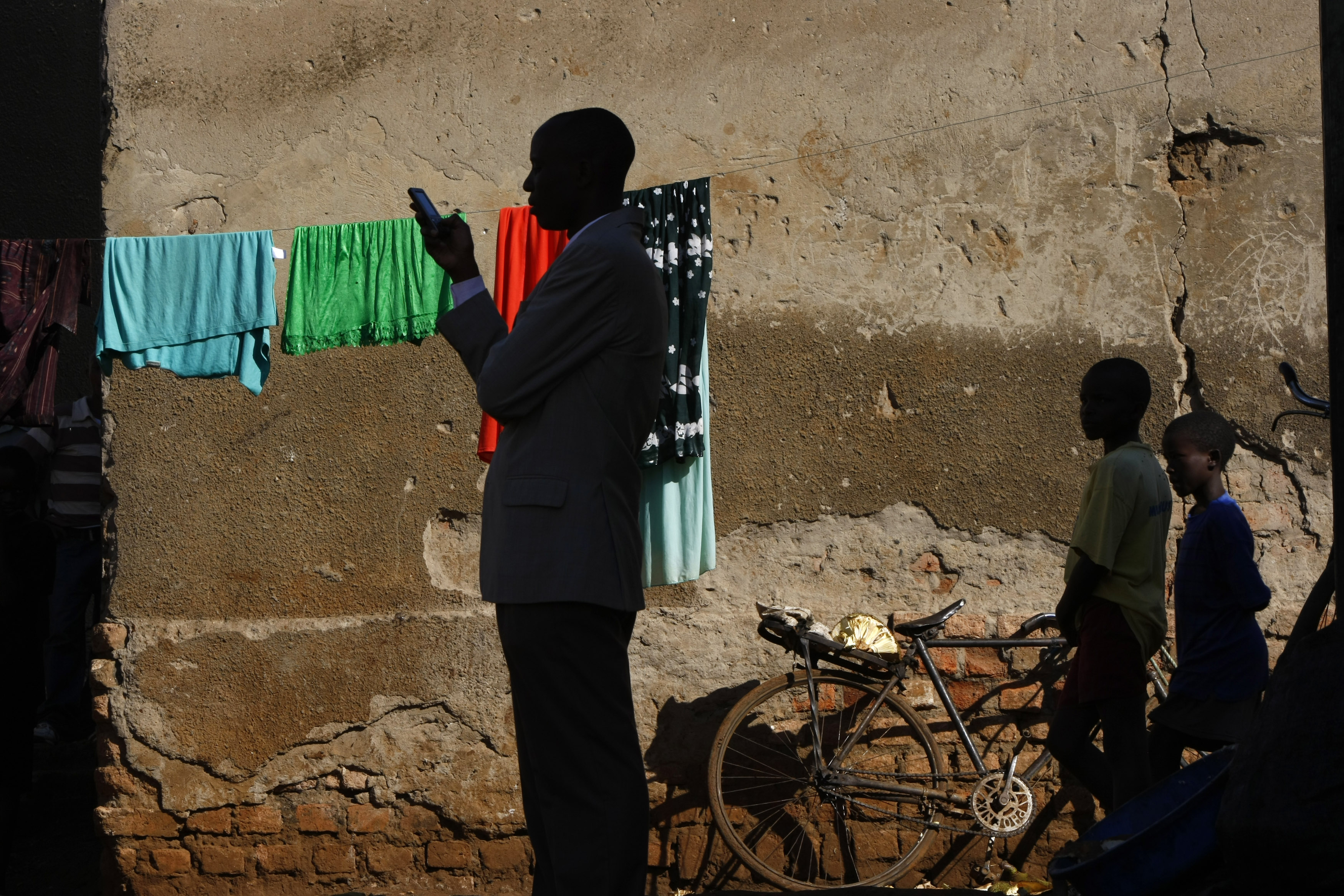 A town official accompanying visiting journalists sends a text message on his phone in the slum of Kachuf in the Masaka district of southern Uganda March 24, 2009. REUTERS/Darrin Zammit Lupi