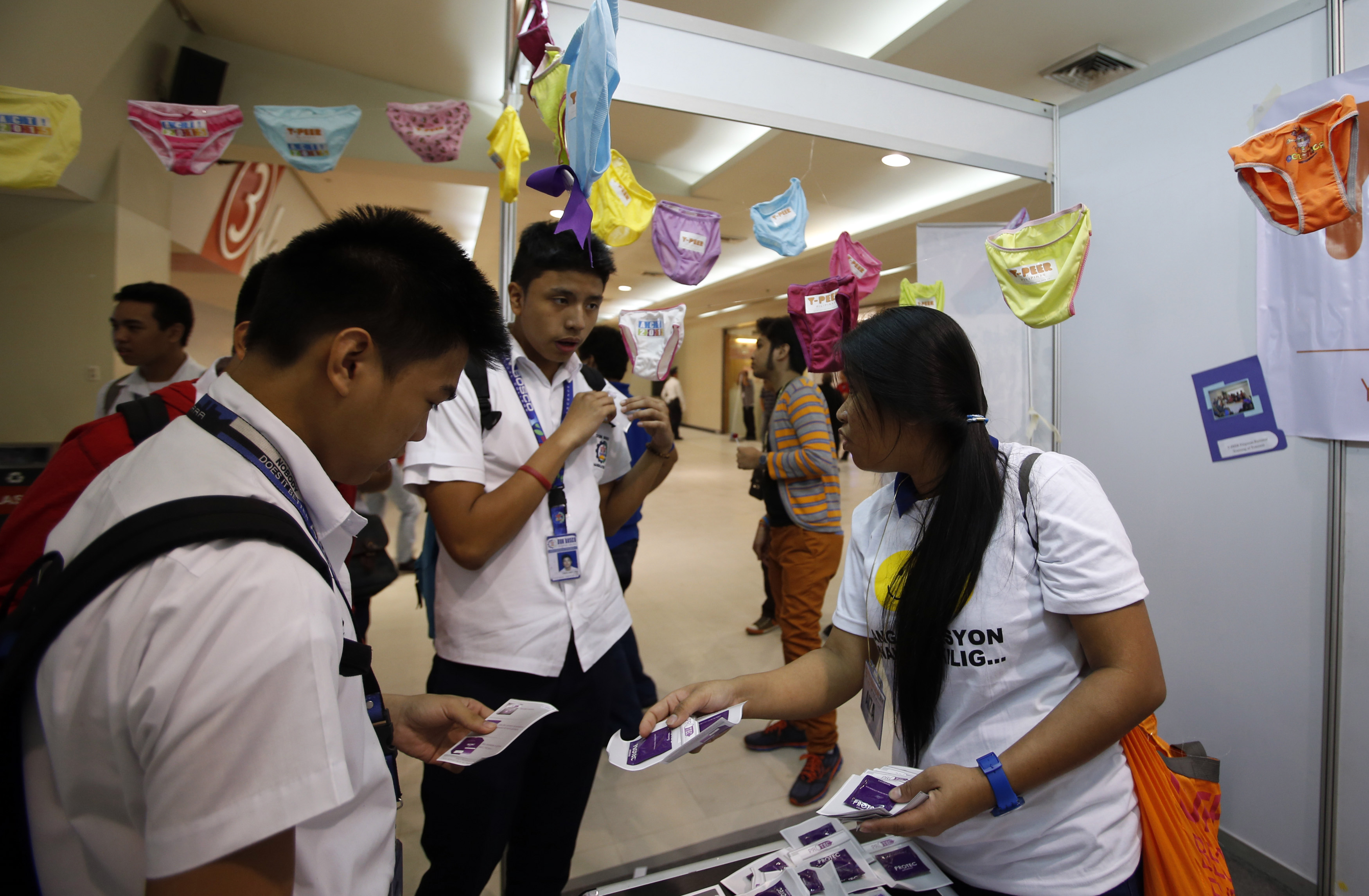Students receive free condoms at an event organised by the United Nations Population Fund (UNFPA) on World Population Day, at a mall in Mandaluyong, Metro Manila, July 11, 2014. REUTERS/Erik De Castro