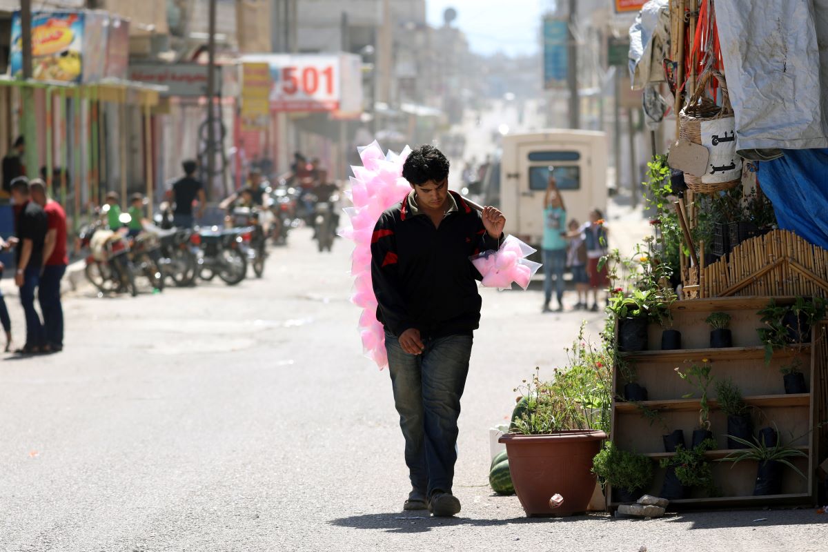 A vendor selling cotton candy walks along a street in Dael, Syria June 15, 2018. REUTERS/Alaa Al-Faqir