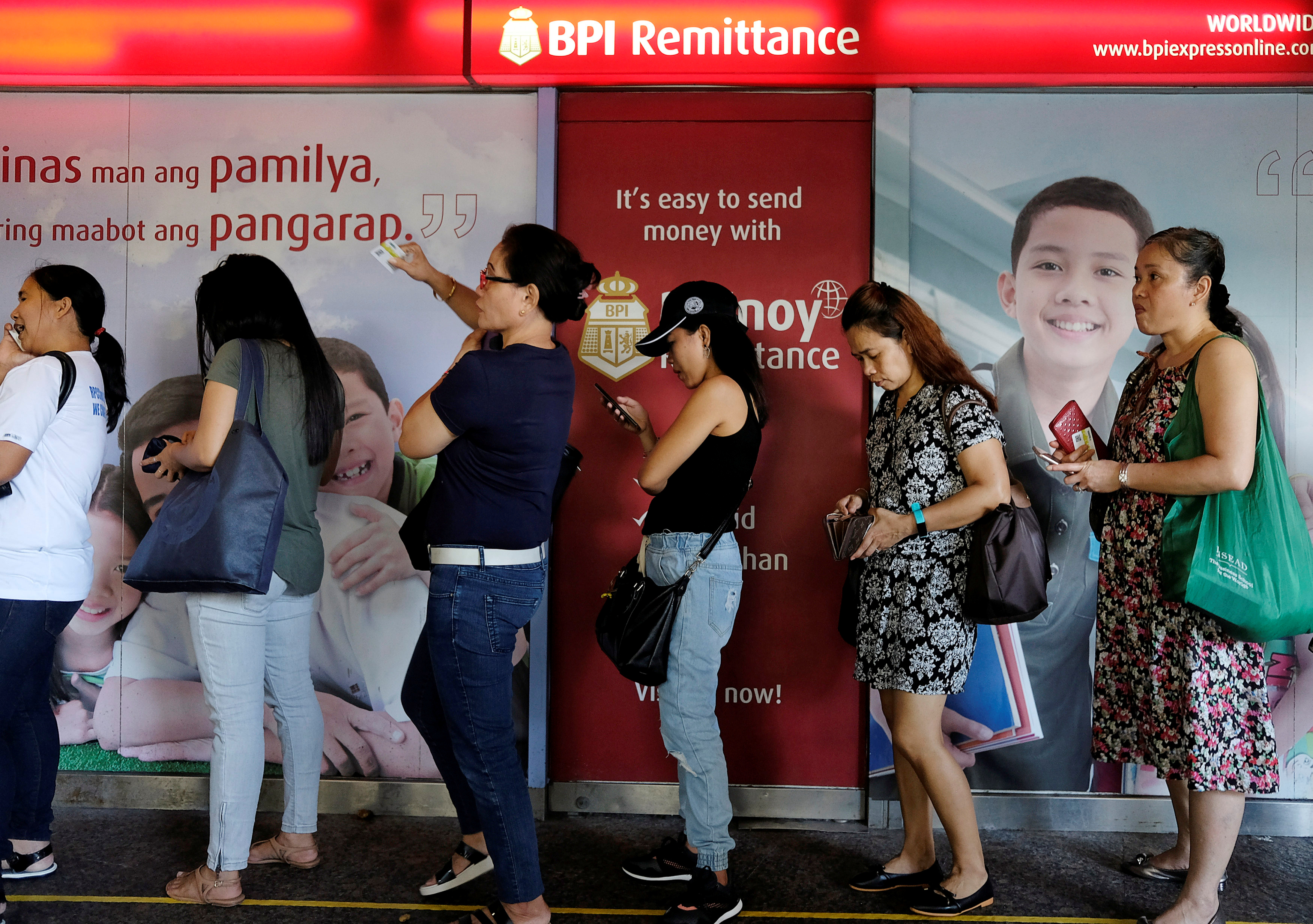 Domestic helpers line up for remittance services inside World Wide Plaza at the financial Central district in Hong Kong, China September 2, 2018. REUTERS/Bobby Yip