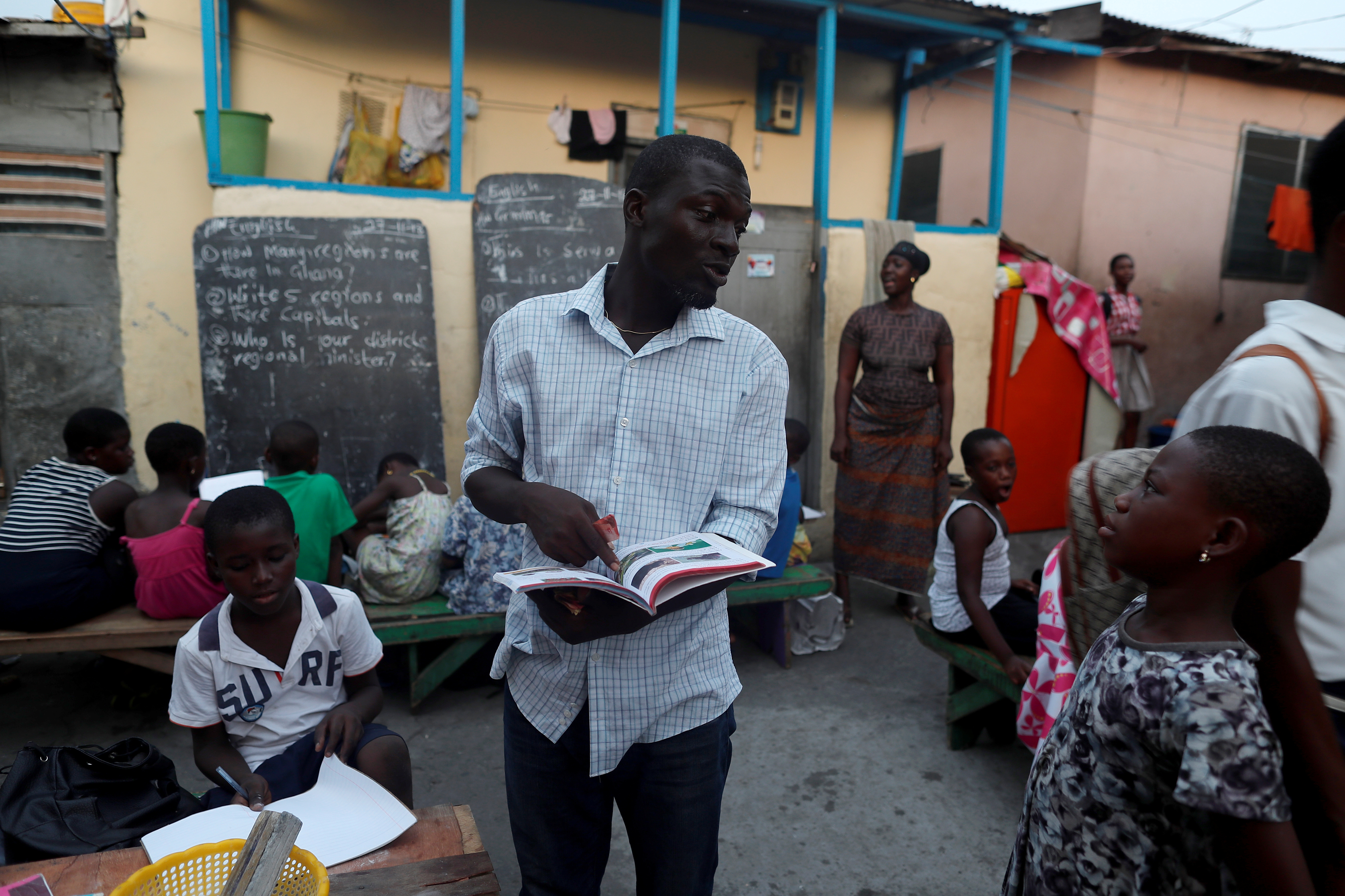 A teacher talks to a boy before he starts the evening class in Jamestown, Accra, Ghana November 28, 2018. REUTERS/Zohra Bensemra