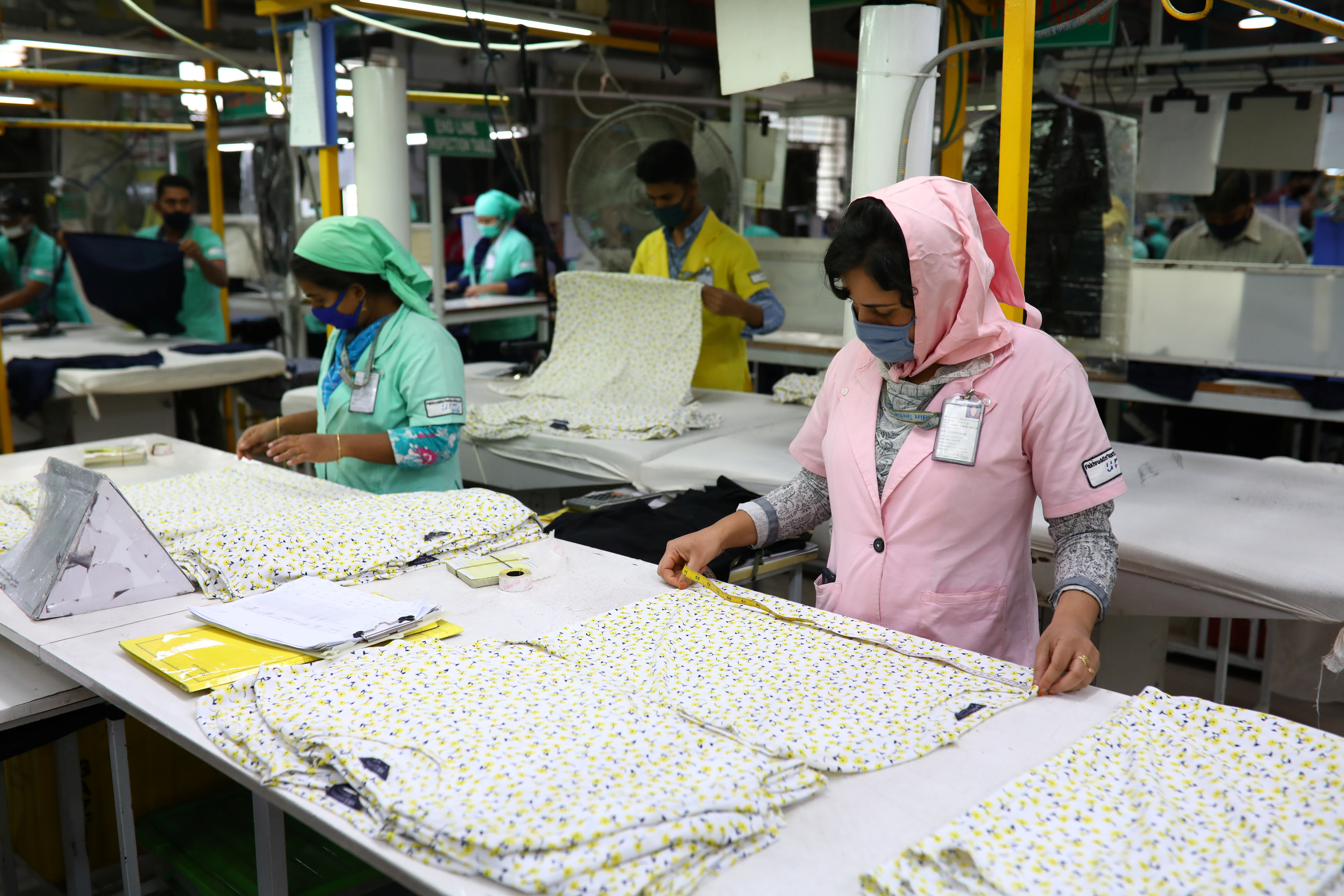 Garment workers check Marks and Spencer (M&S) t-shirts measurements at the Fakhruddin Textile Mills Limited in Gazipur, Bangladesh, February 7, 2021. REUTERS/Mohammad Ponir Hossain
