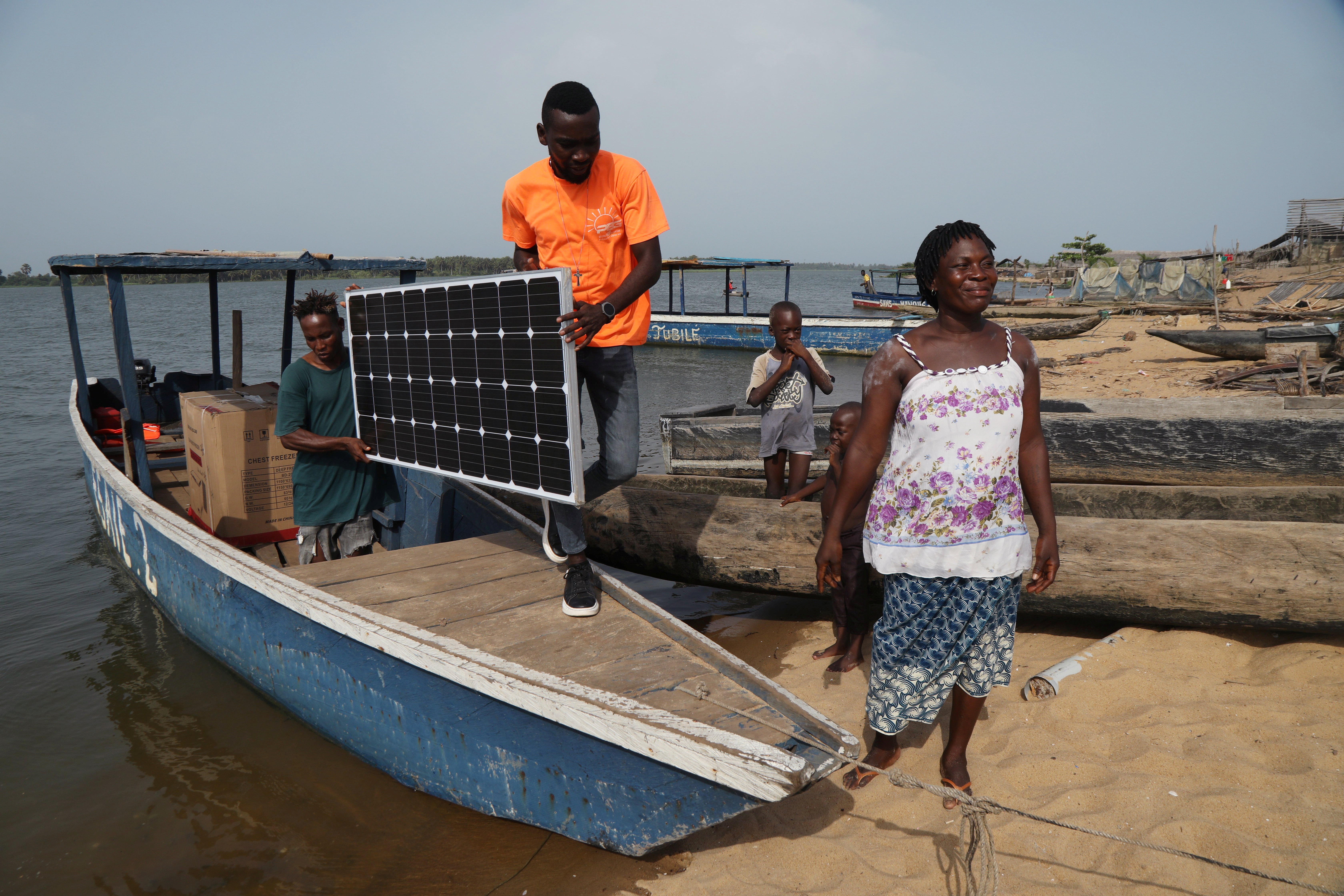 PEG Africa agents carry a solar panel as they unload a solar-powered fridge from a boat in Lahou-Kpanda, Ivory Coast, February 25, 2021. REUTERS /Luc Gnago