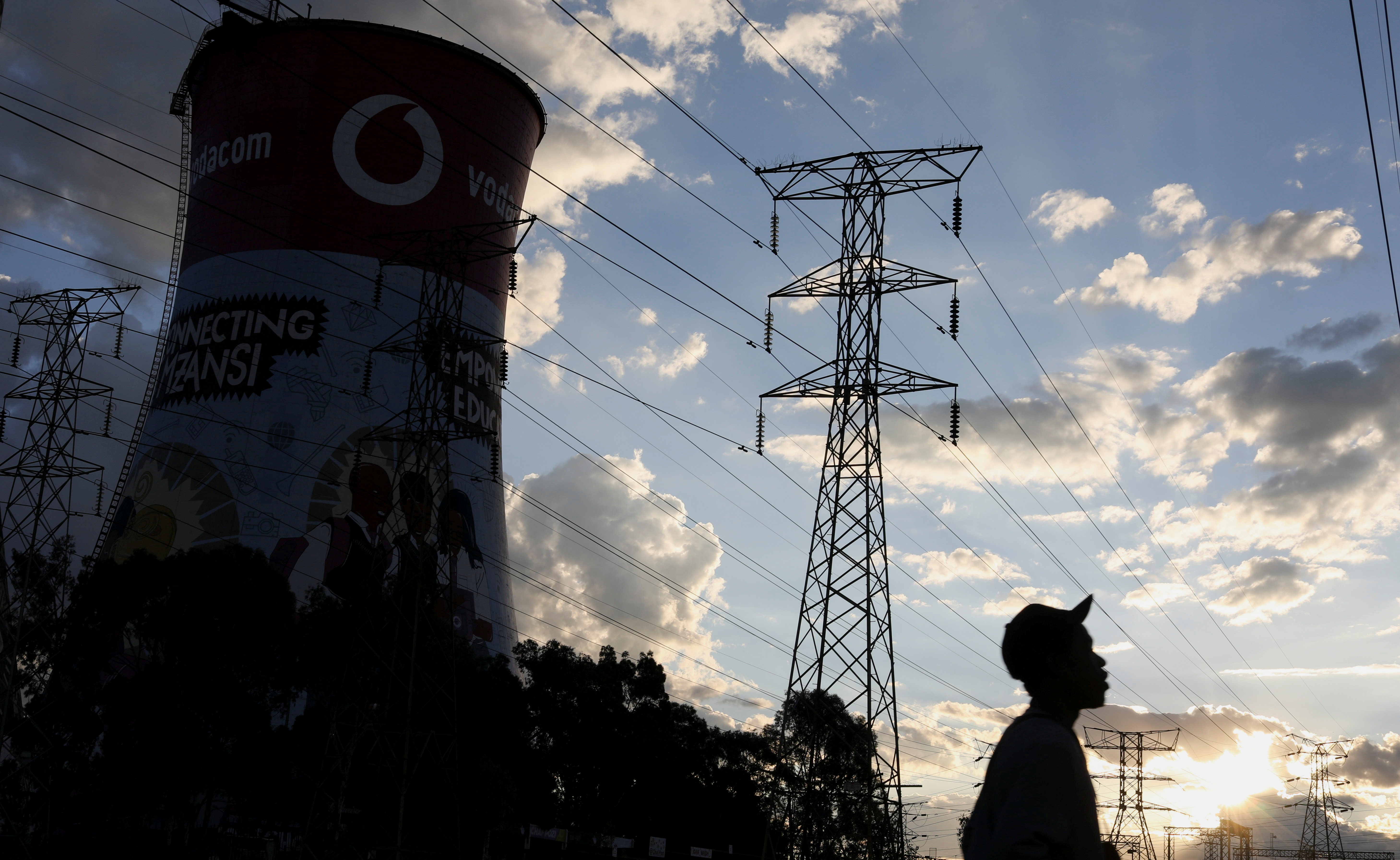 A man walks below Eskom's electricity pylons in Soweto, South Africa, March 18, 2021. REUTERS/Siphiwe Sibeko