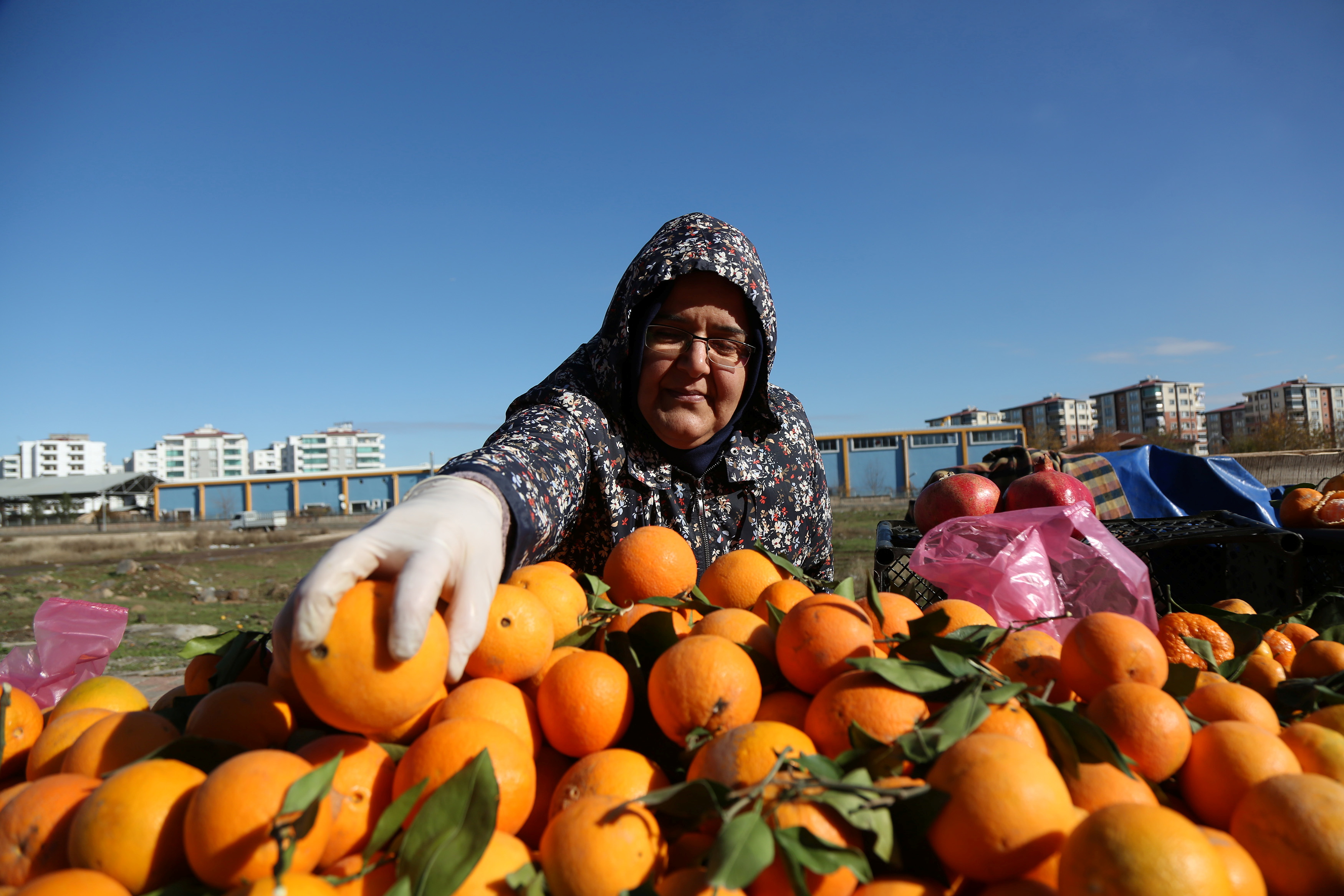 Street vendor arranges oranges at her stall in a women-led street market in Diyarbakir, Turkey December 22, 2021. REUTERS/Sertac Kayar