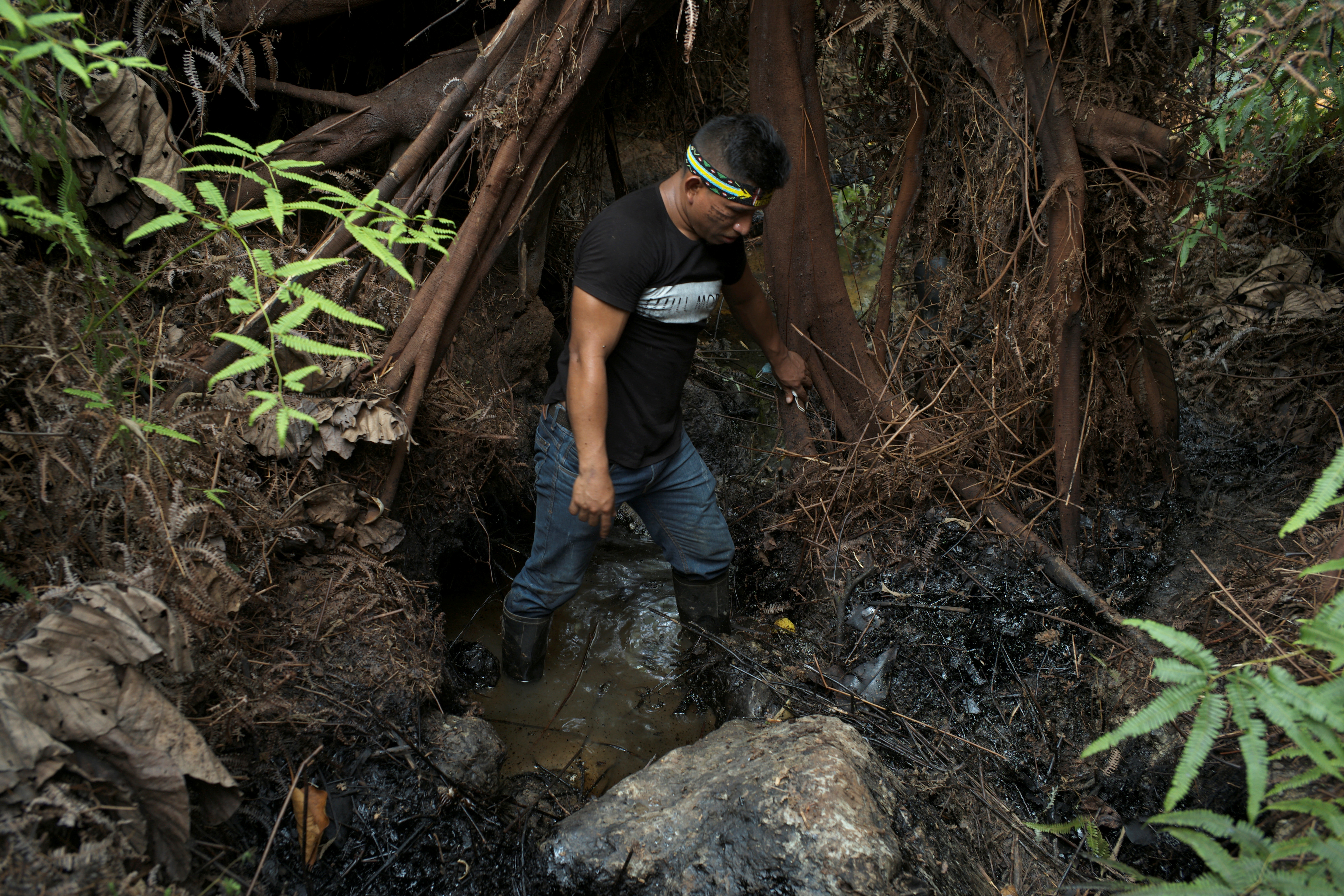 A community leader, shows oil contamination inside Block 192, a dormant Amazon oil field near Nuevo Andoas, Peru February 21, 2022.  REUTERS/Alessandro Cinque