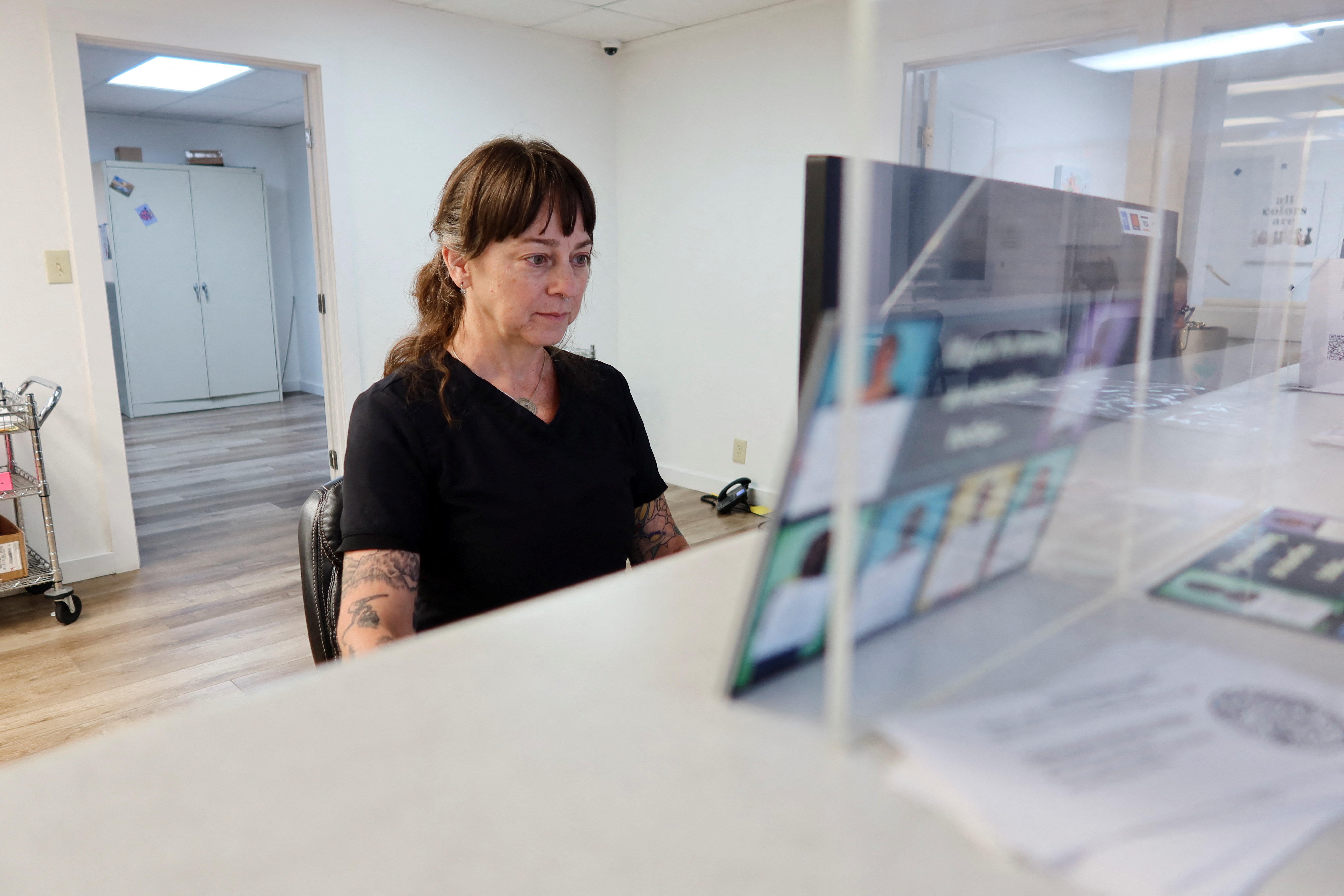 A health care worker sits at her computer inside Tulsa Women's Clinic, filing reports of abortions, in Oklahoma, U.S. June 20, 2022. REUTERS/Liliana Salgado