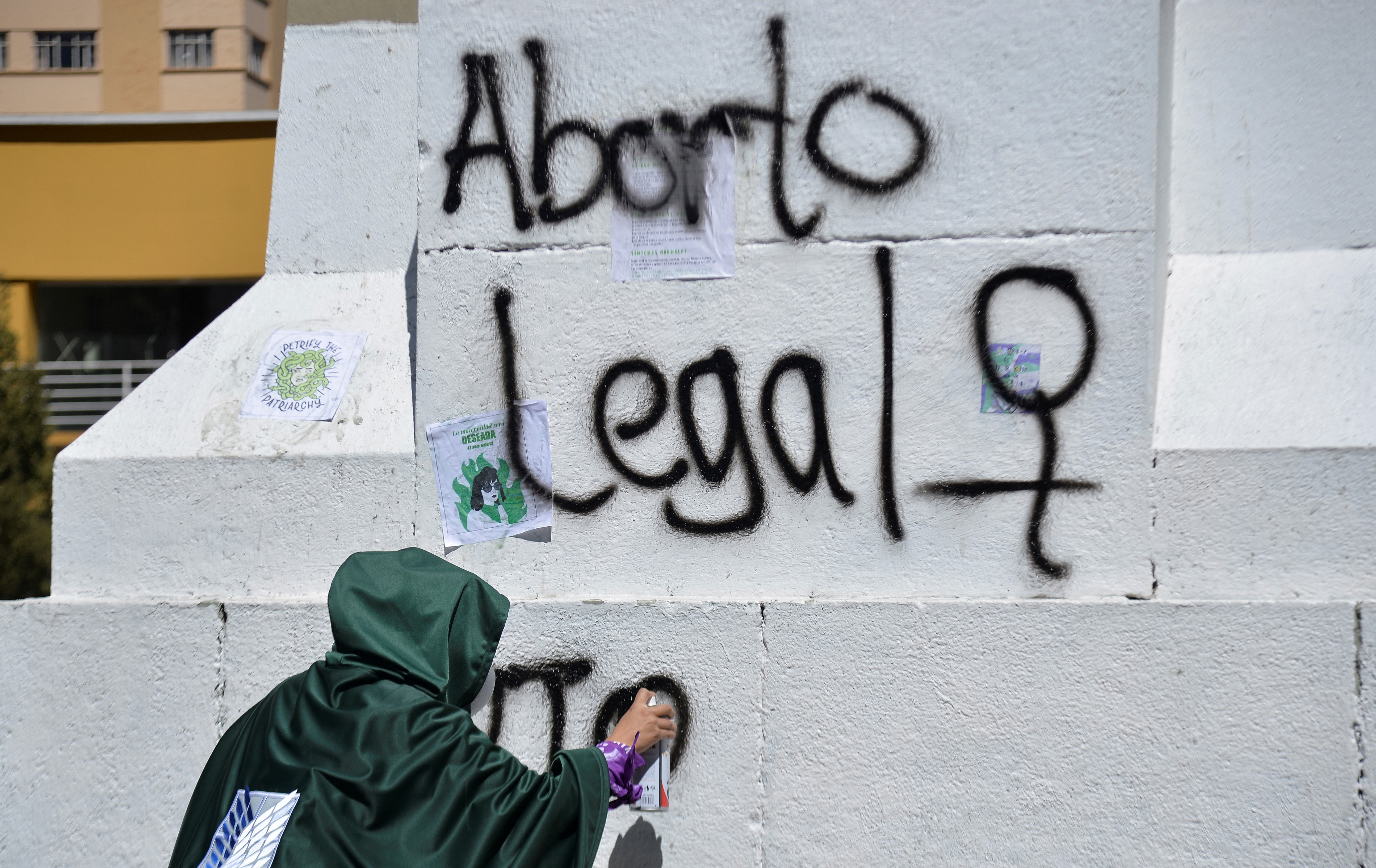 A woman sprays paint a monument with the phrase "Legal Abortion" during International Safe Abortion Day, in La Paz, Bolivia September 28, 2022. REUTERS/Claudia Morales