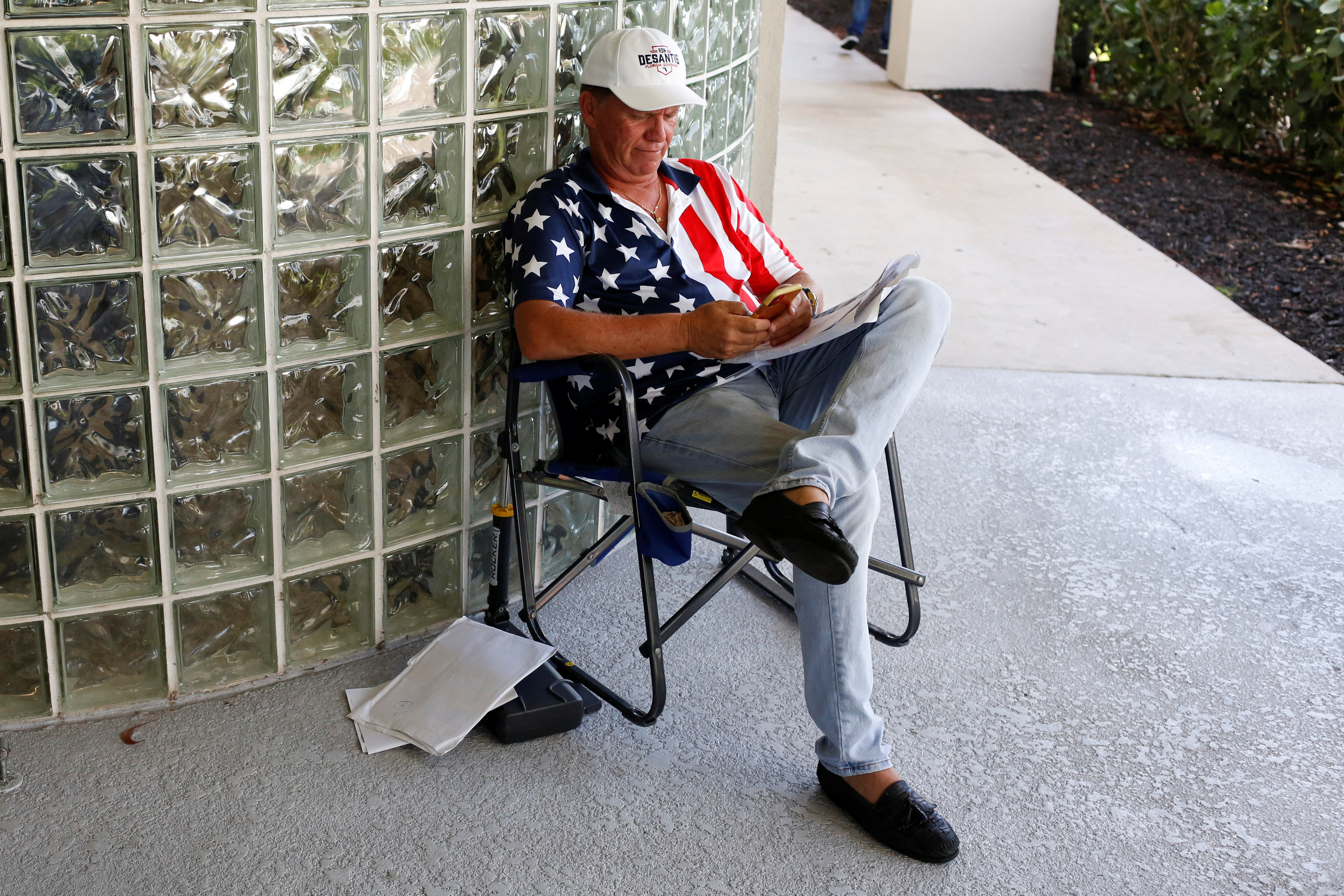 A supporter of Florida Governor Ron DeSantis checks his phone during the Florida Election Integrity Public Hearing event in West Palm Beach, Florida, U.S. September 10, 2022