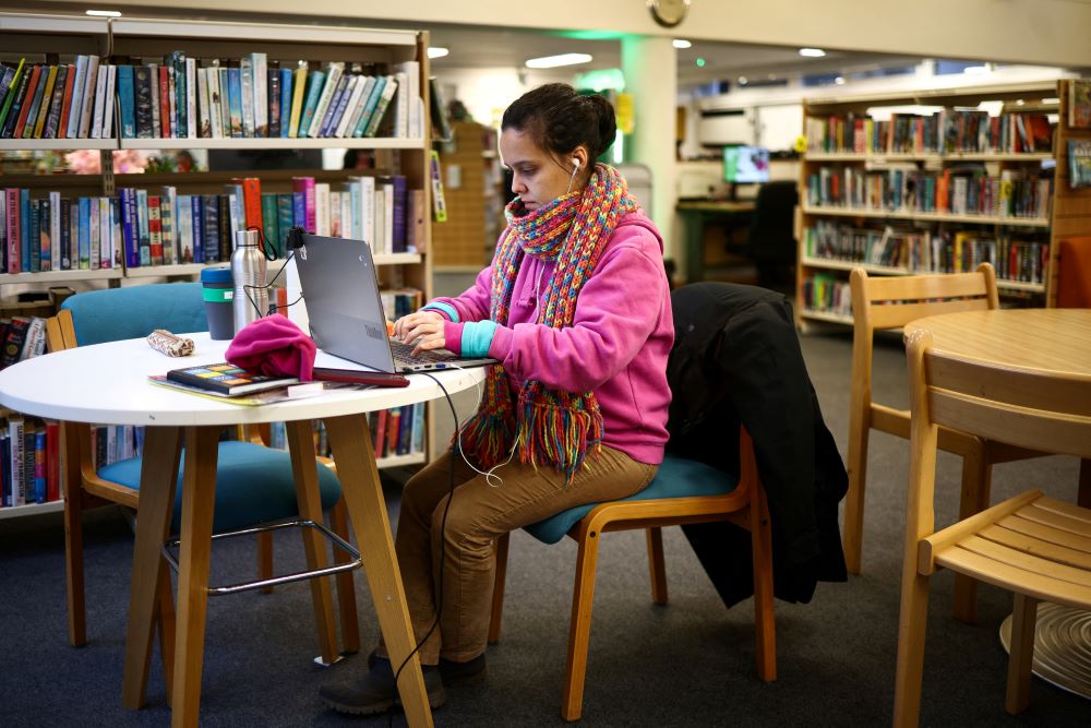 A local resident uses a laptop inside the Roehampton Library, that is being used as a "warm bank", welcoming members of the community to spend time there in the winter months as an alternative to heating their homes amid increased energy costs, in London, Britain, December 14, 2022