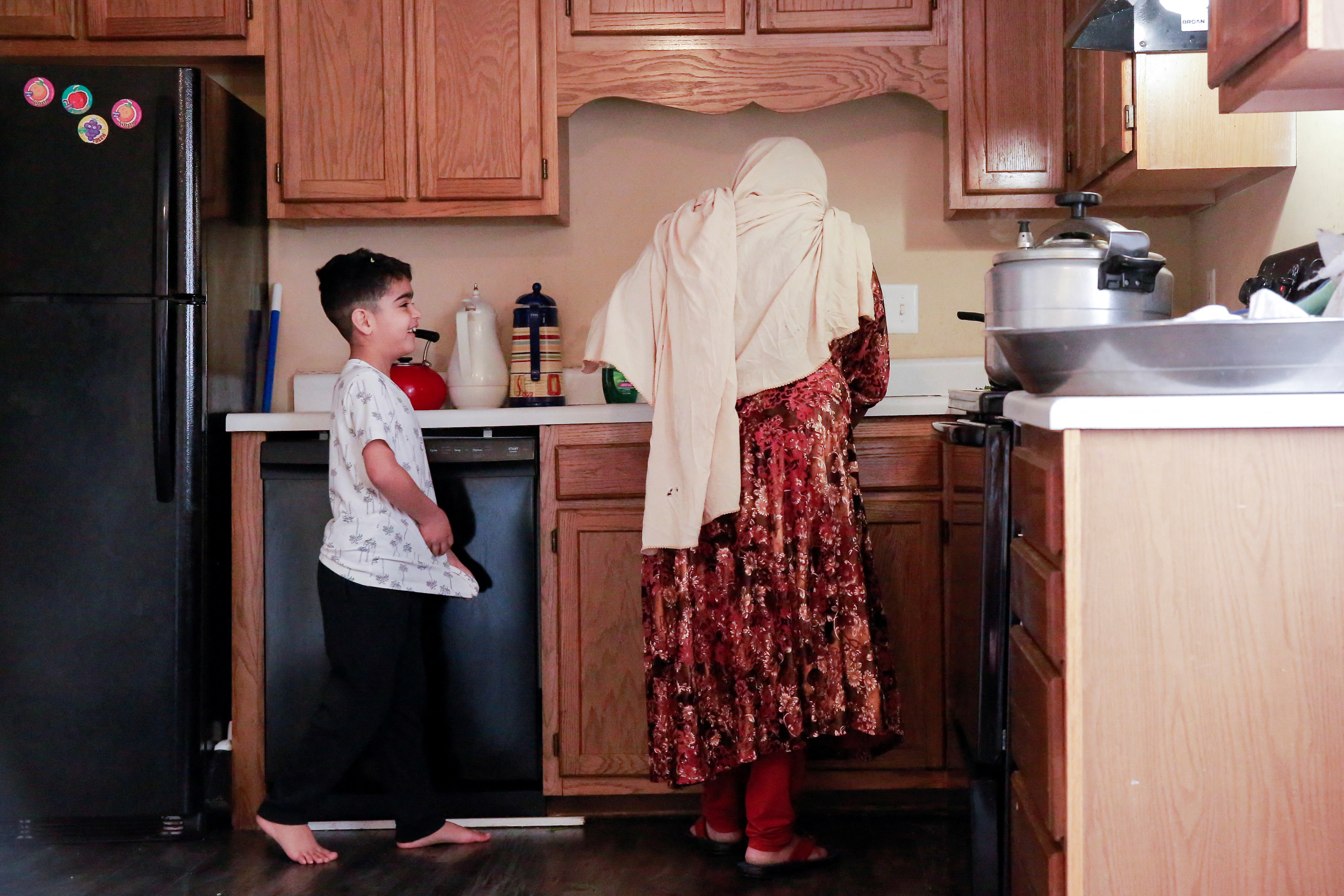 An Afghan refugee and her son talk in the kitchen at their new home in Bowling Green, Kentucky, U.S., January 7, 2023. REUTERS/Amira Karaoud