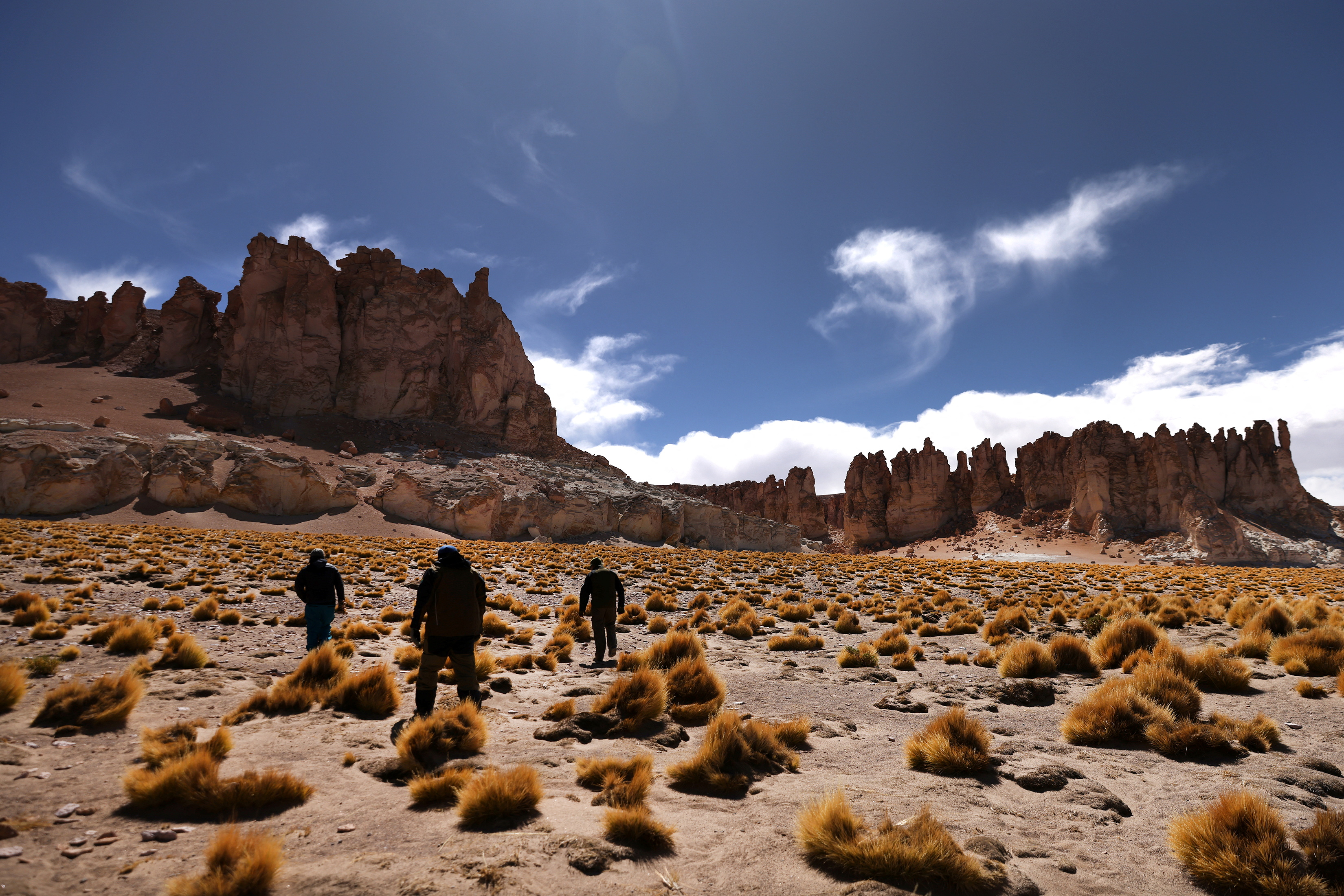 Forestry rangers walk towards La Catedral, a rock formation of the Tara salt flat, in Los Flamencos National Reserve, in Chile, May 5, 2023. REUTERS/Ivan Alvarado