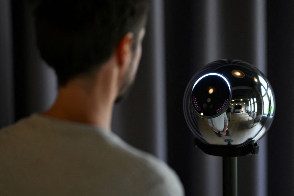 Ricardo Macieira, regional manager, Europe stands to simulate the iris scan near the biometric imaging device, the Orb of the identity and financial public utility Worldcoin, to create a World ID digital passport, being able to trade in cryptocurrency issued, in Berlin, Germany