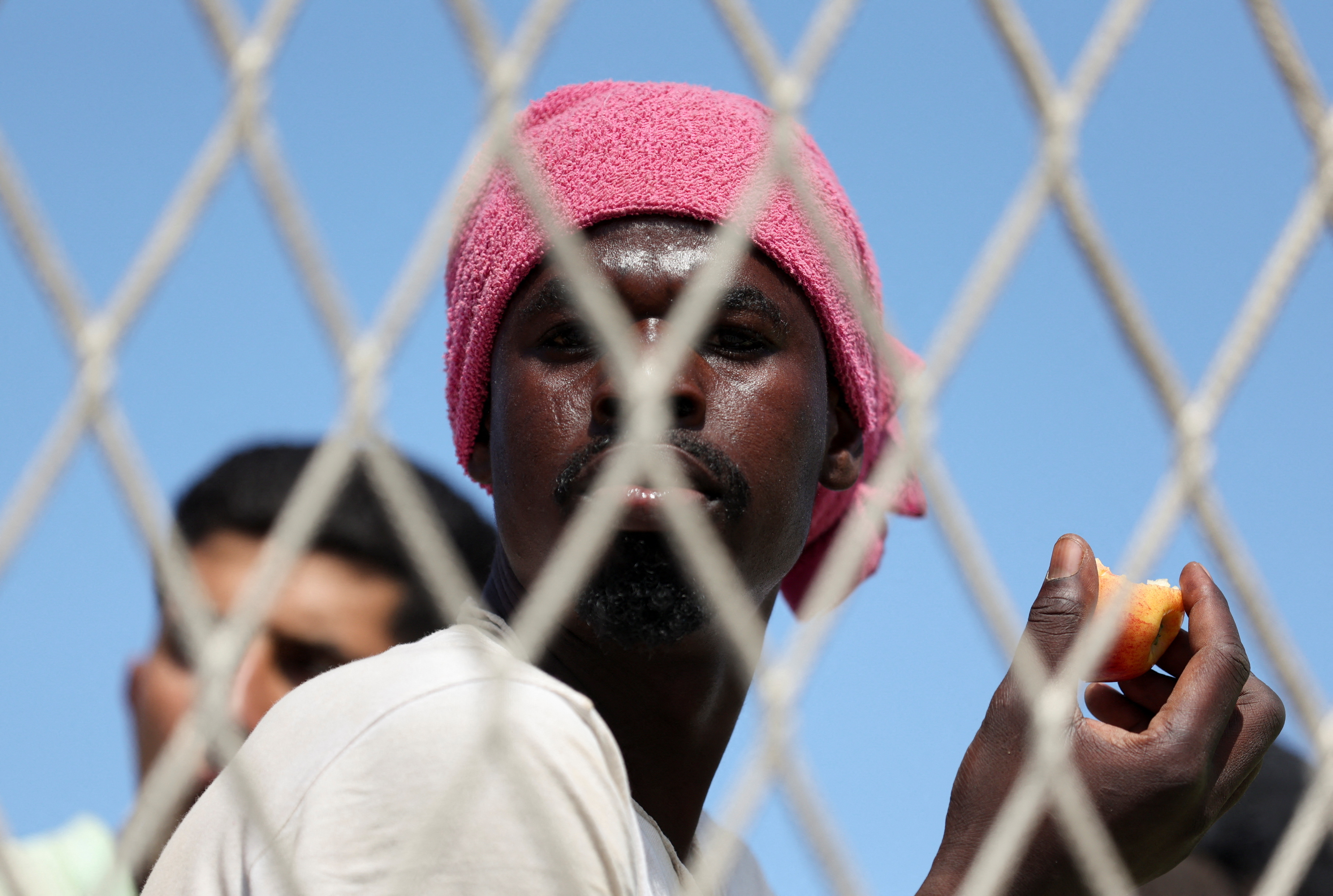 A migrant looks on as he sits on the deck of the military ship 'Cassiopea' to be transferred to the mainland, on the Sicilian island of Lampedusa, Italy, September 15, 2023. REUTERS/Yara Nardi