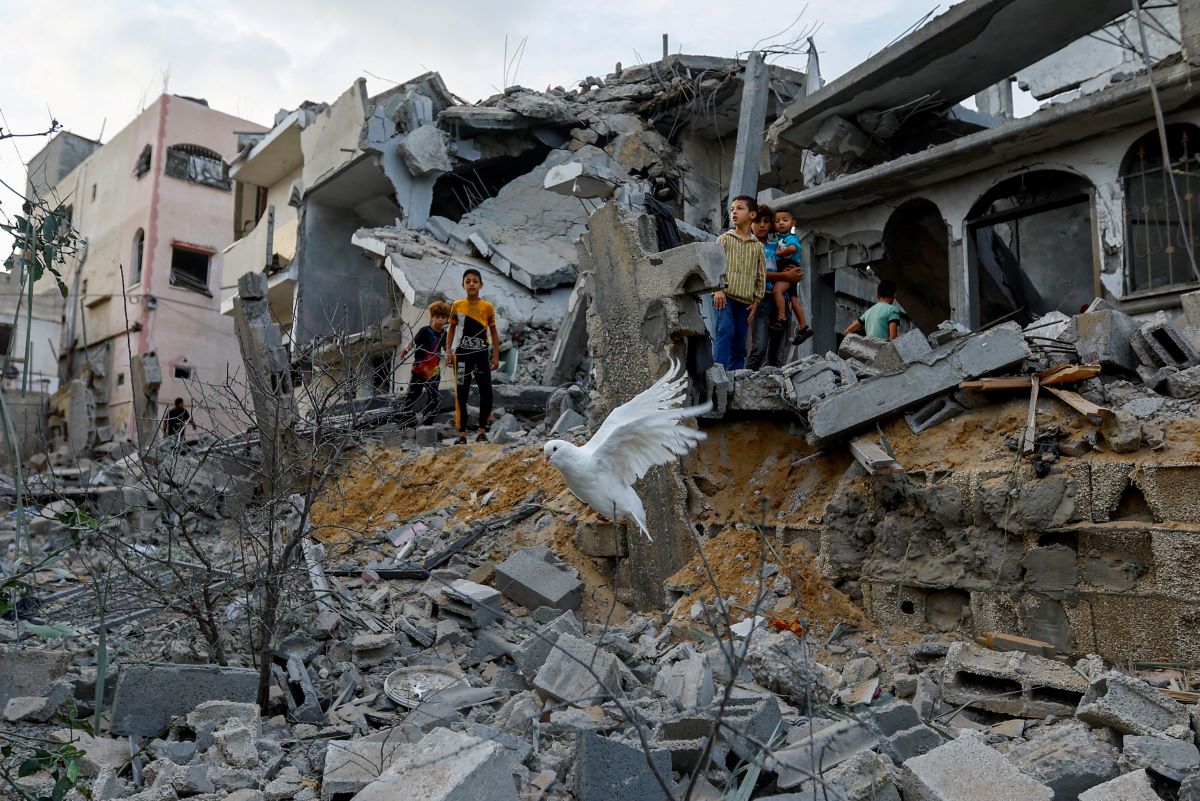 A dove flies over the debris of houses destroyed in Israeli strikes, in Khan Younis in the southern Gaza Strip October 11, 2023