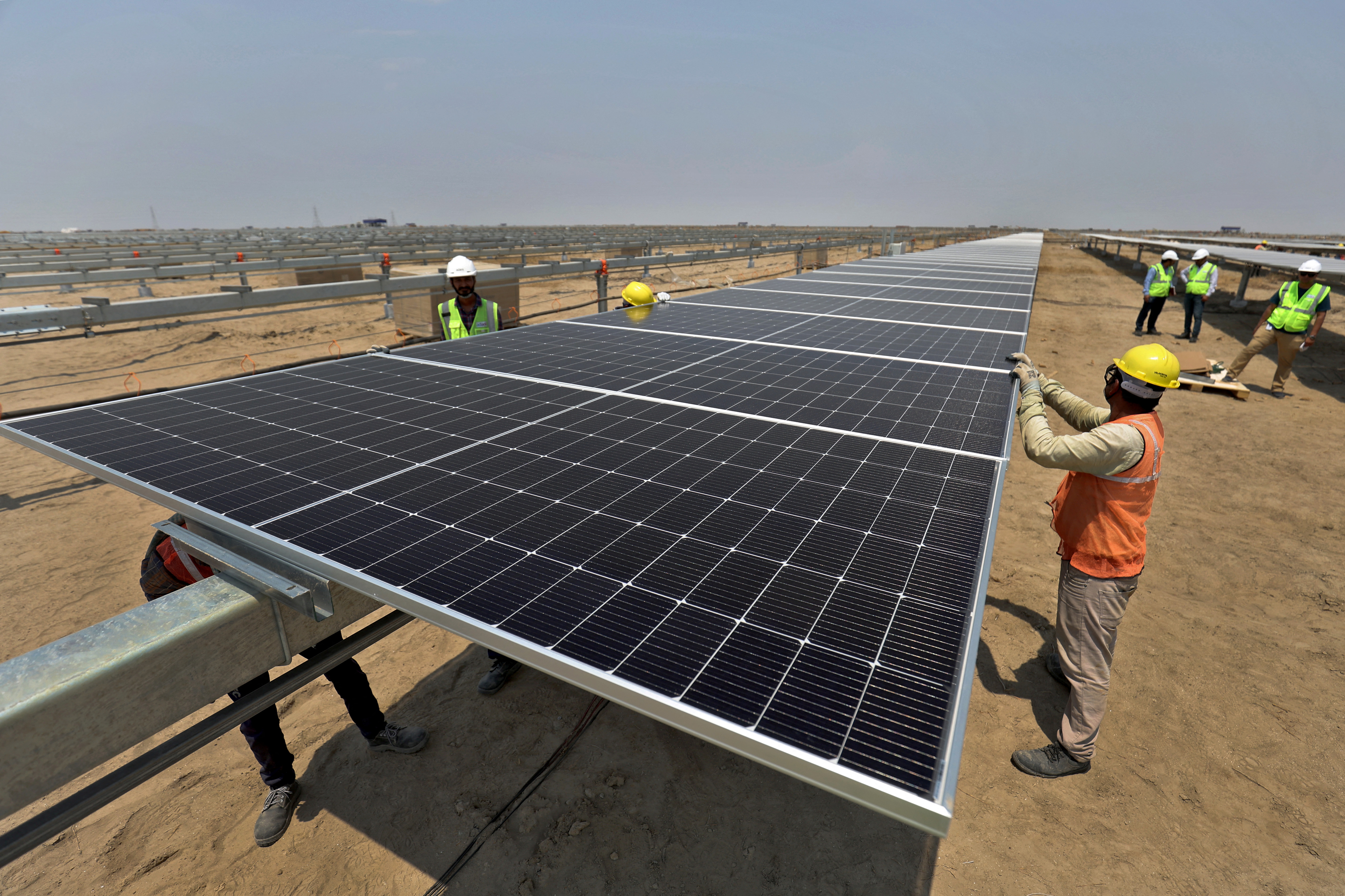 Workers install solar panels at the Khavda Renewable Energy Park of Adani Green Energy Ltd (AGEL) in Khavda, India, April 12, 2024.REUTERS/Amit Dave