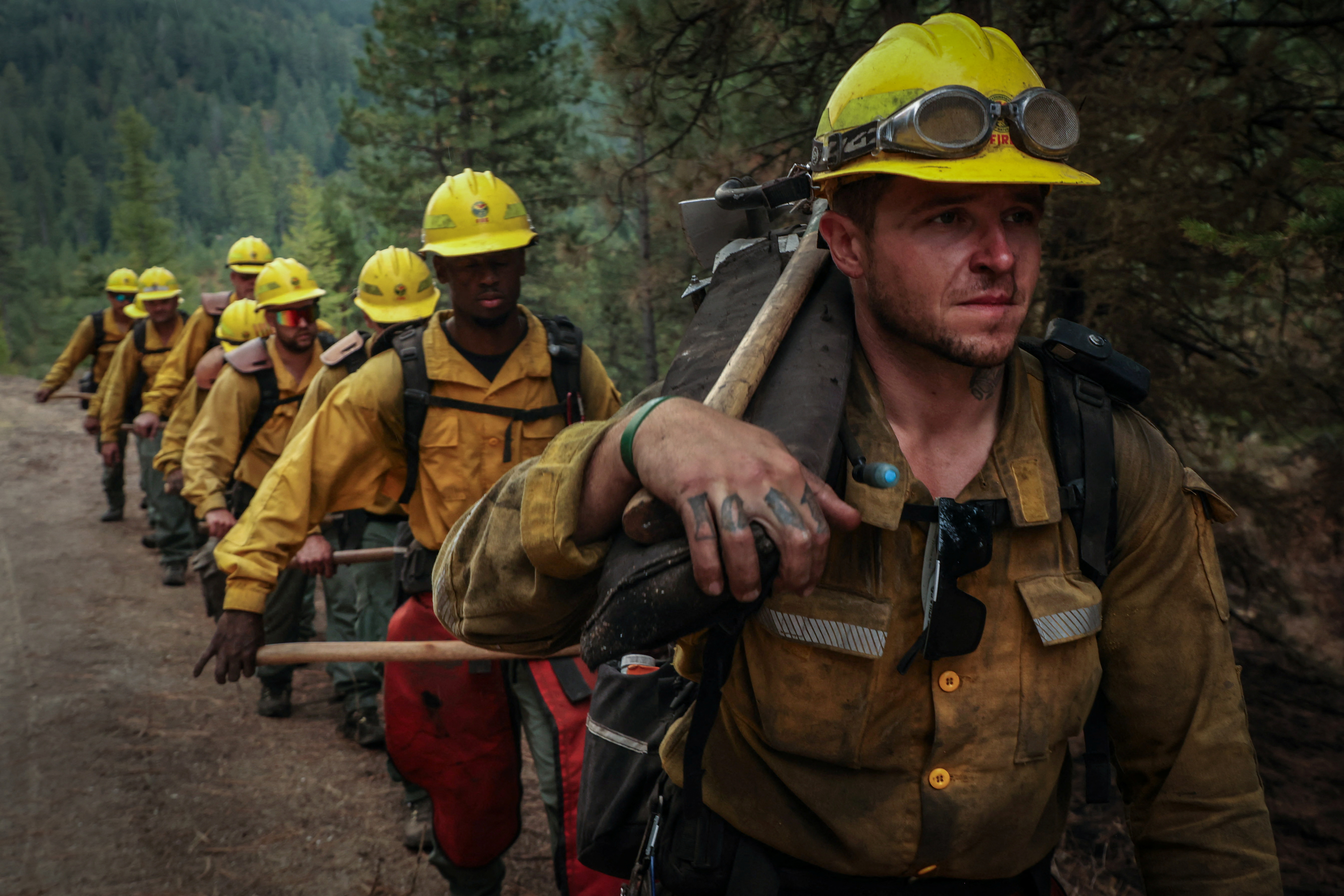 A group of partially-incarcerated firefighters march along a forest road on deployment at the Oregon fire near Deer Park, Washington, U.S., August 30, 2023. REUTERS/Matt Mills McKnight