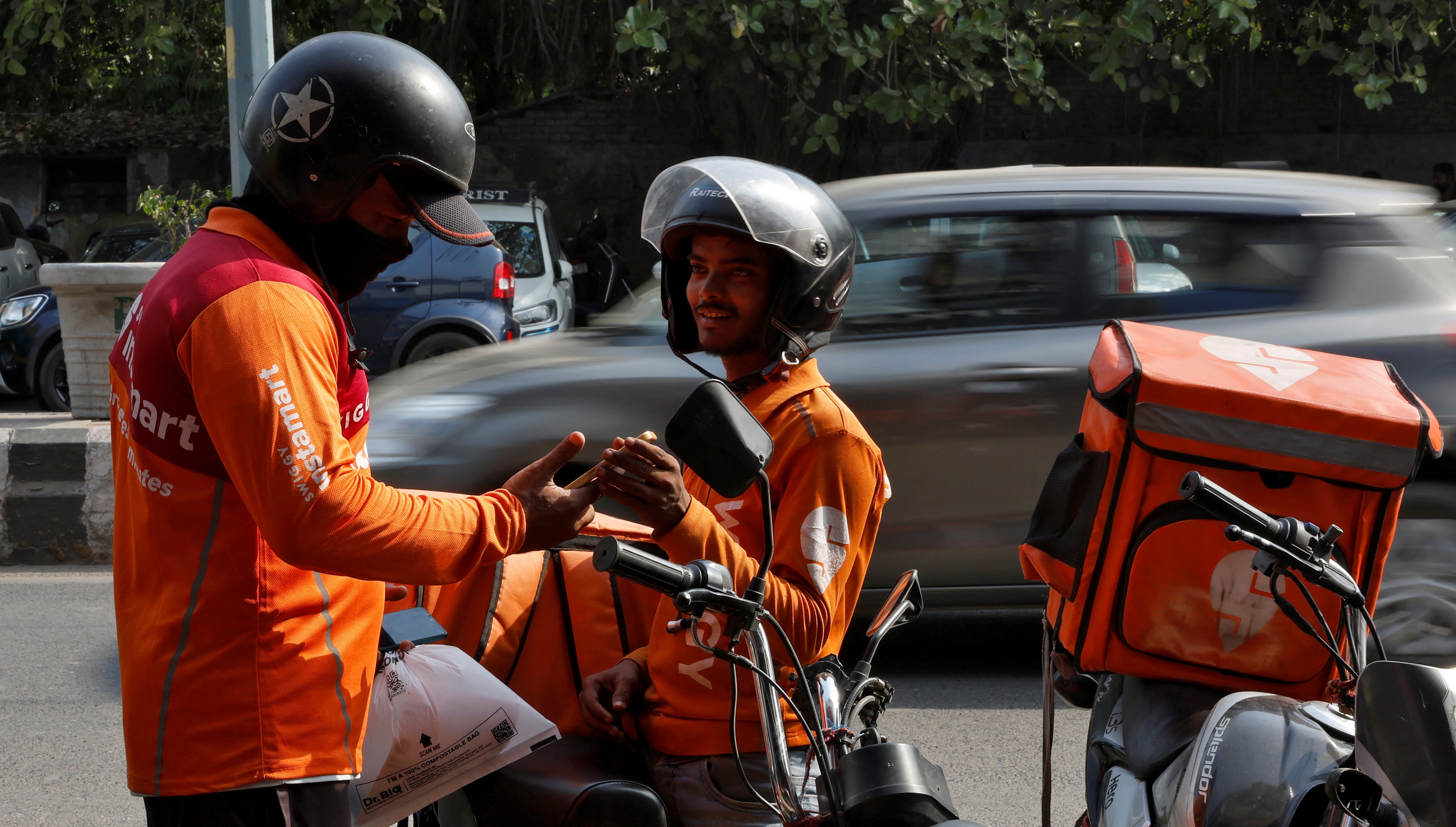 Gig workers prepare to deliver orders outside Swiggy's grocery warehouse at a market area in New Delhi, India, May 6, 2024. REUTERS/Priyanshu Singh