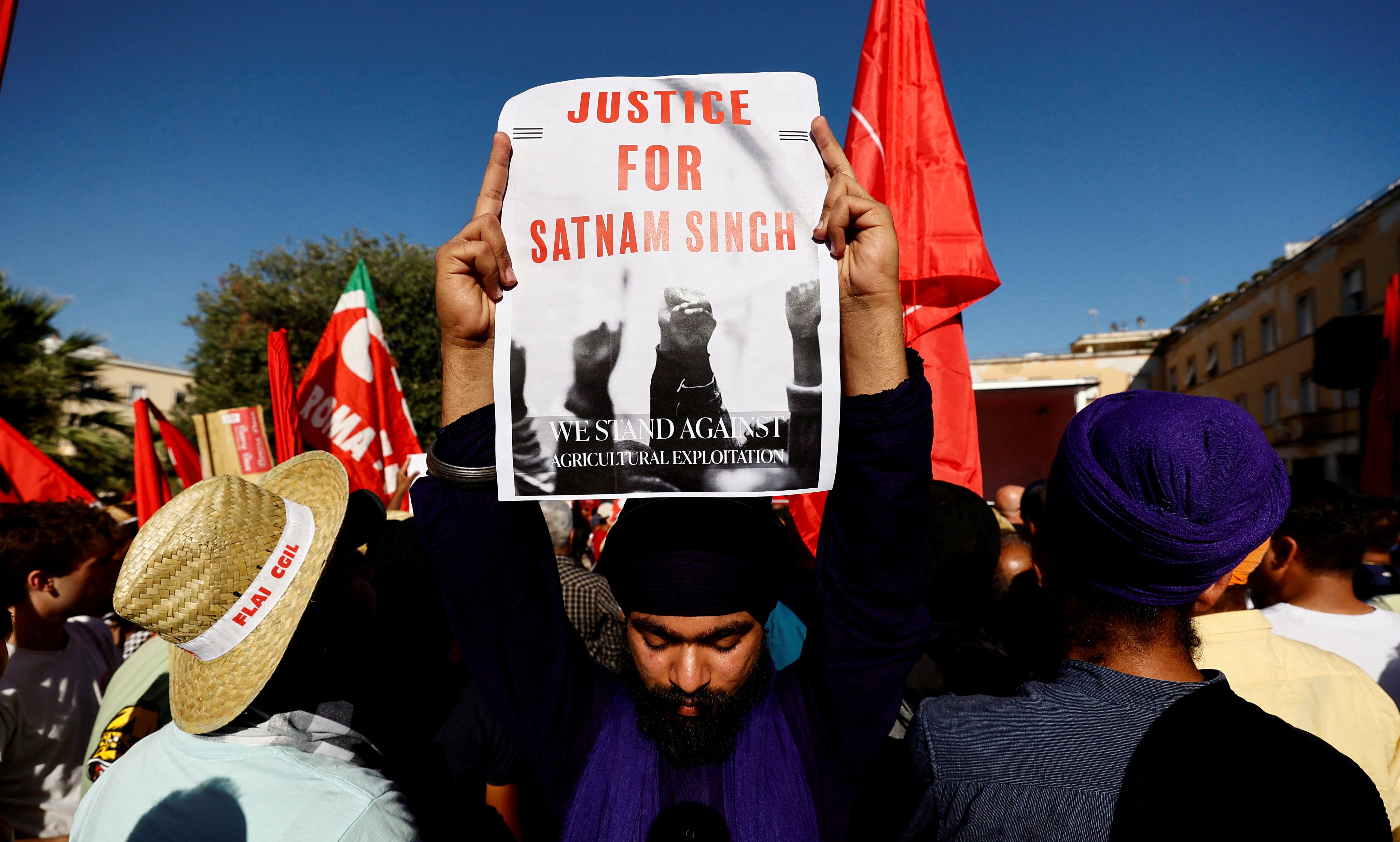 A demonstrator holds a placard that reads: "Justice for Satnam Singh" during a protest following the death of an Indian farm labourer, Satnam Singh in Latina, Italy June 22, 2024. REUTERS/Stringer