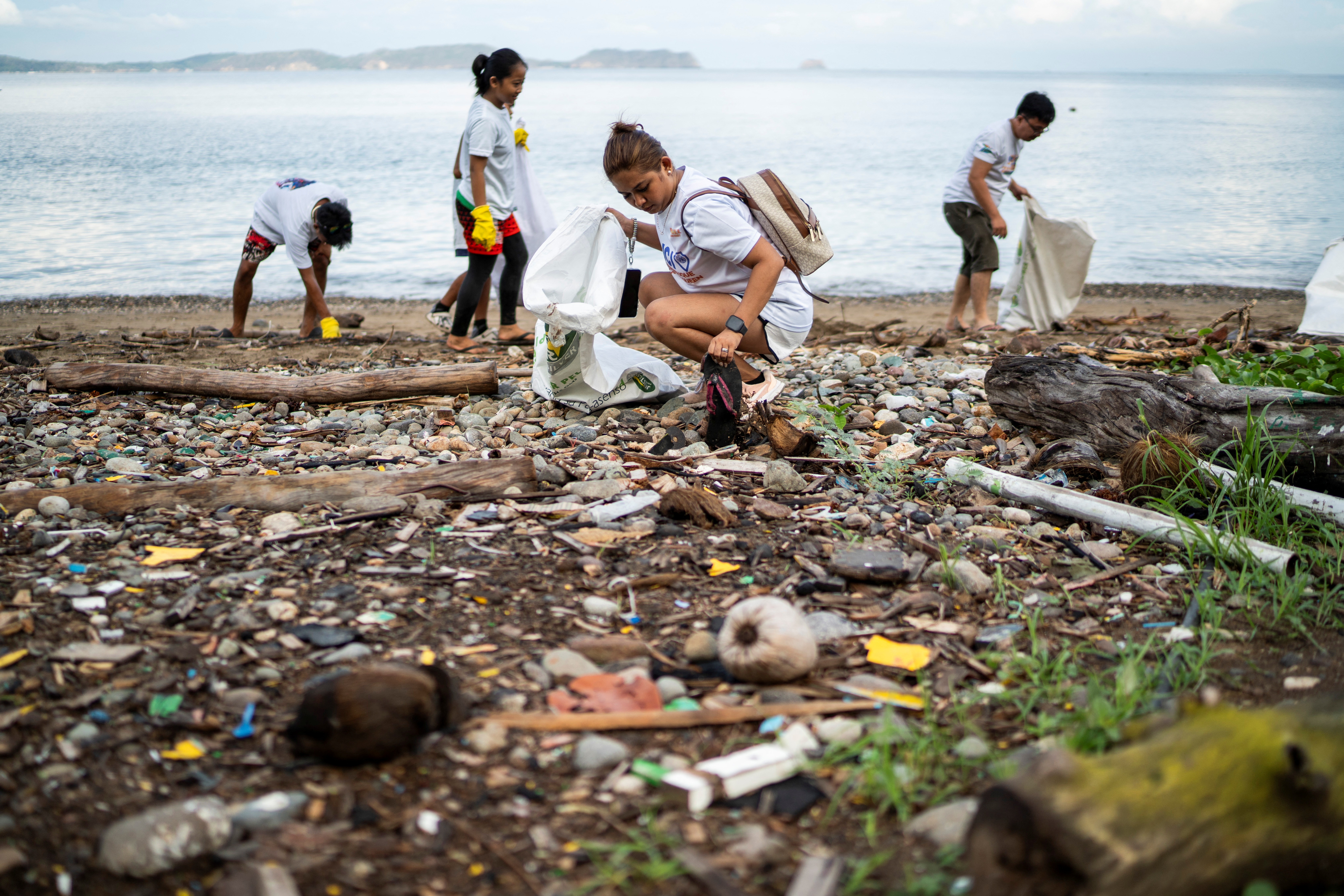 People collect plastic waste on a beach during a coastal cleanup program in Mabini, Batangas province, Philippines, June 15, 2024. REUTERS/Lisa Marie David