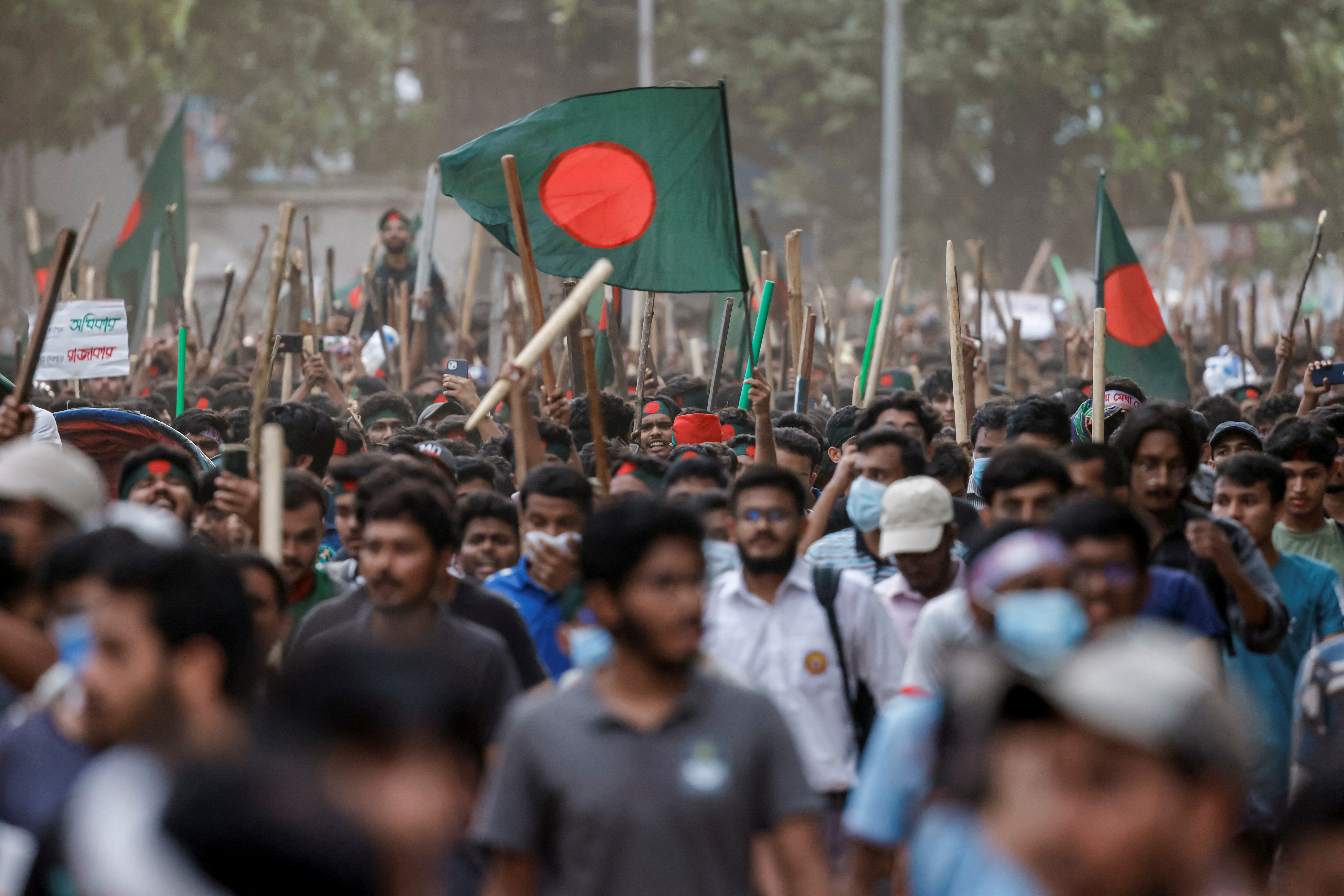 Anti-quota protesters march with Bangladeshi flags and sticks, at the University of Dhaka, in Dhaka, Bangladesh, July 16, 2024. REUTERS/Mohammad Ponir Hossain