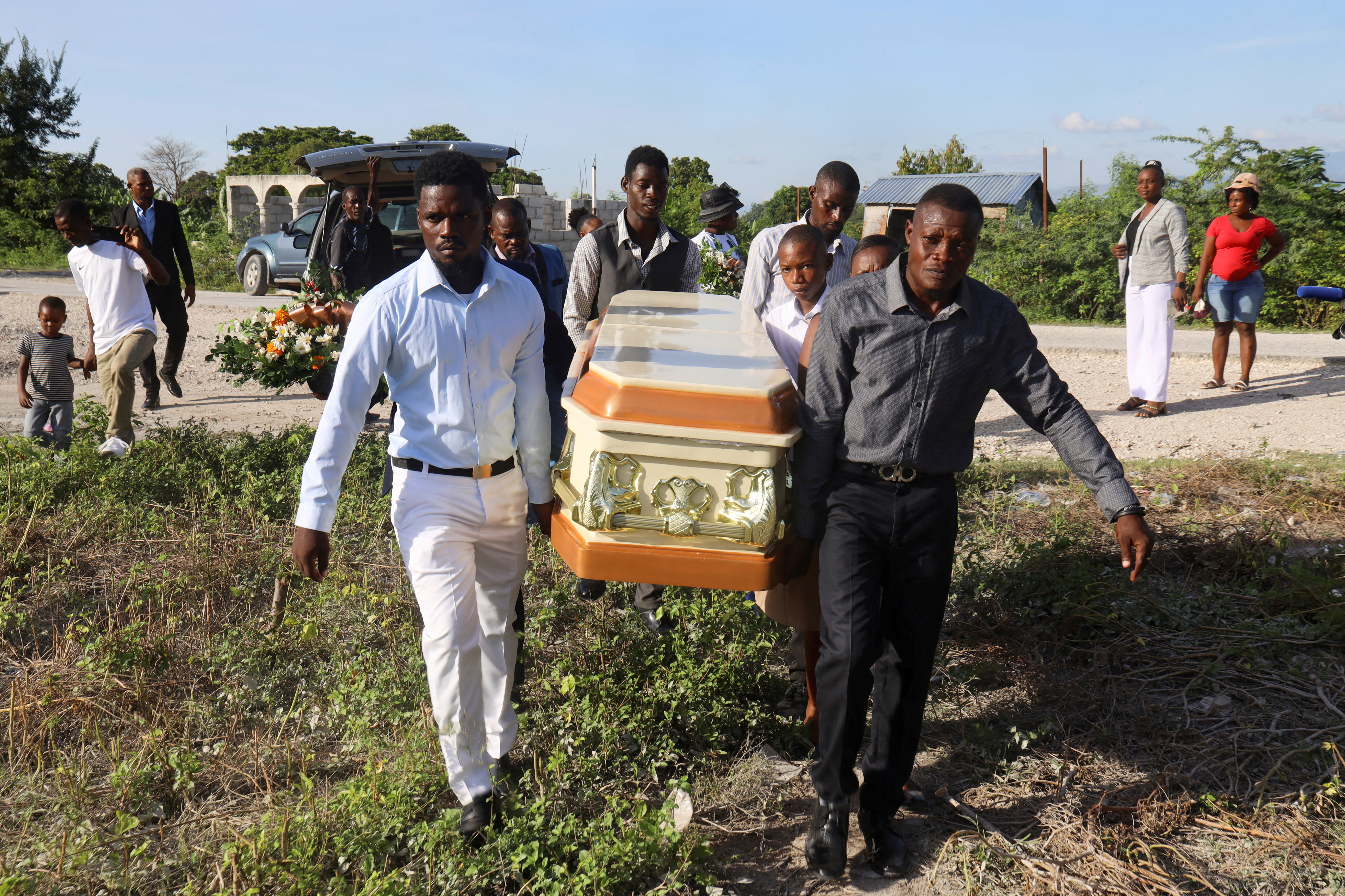 Friends and family members carry the casket of a person killed in the October 3 attack by members of the Gran Grif gang, to a tomb during a funeral service in Pont-Sonde, Haiti October 8, 2024. REUTERS/Marckinson Pierre