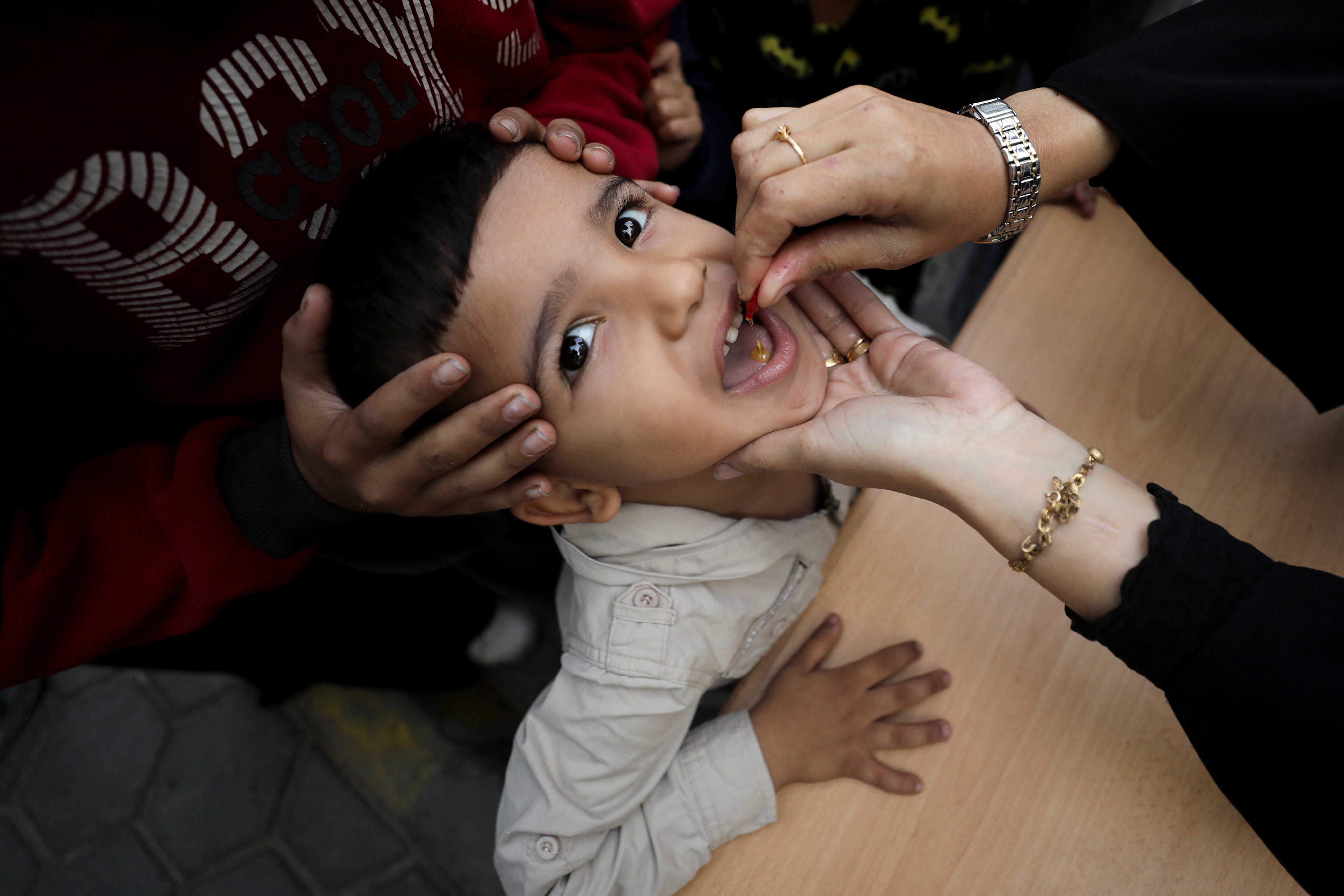 A Palestinian child is vaccinated against polio during the second round of a vaccination campaign, amid the Israel-Hamas conflict, in Gaza City, November 2, 2024. REUTERS/Dawoud Abu Alkas