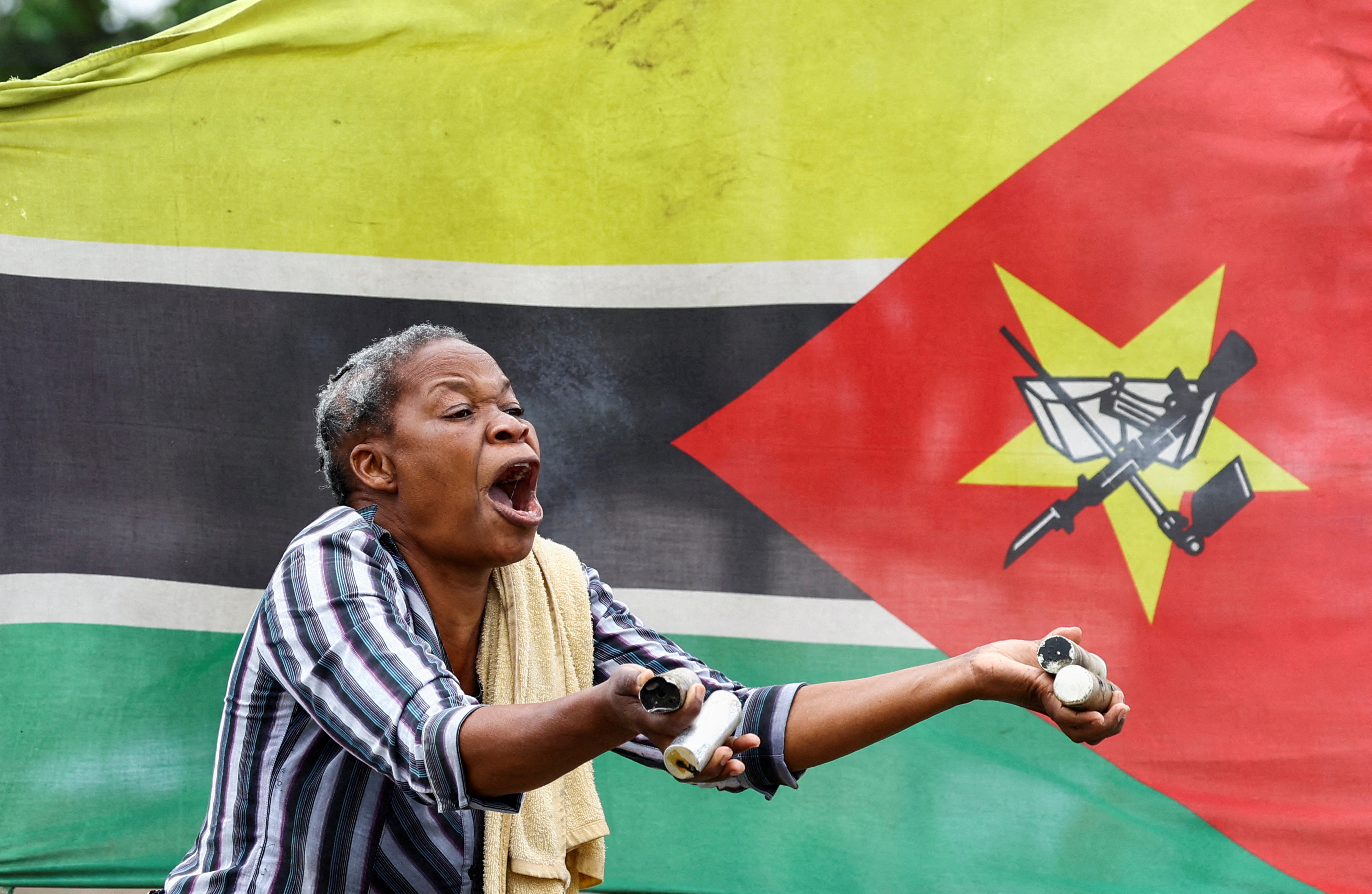 A woman reacts while holding used teargas cannisters after police officers fired at a crowd gathering during a "national shutdown" against the election outcome, at Luis Cabral township in Maputo, Mozambique, November 7, 2024. REUTERS/Siphiwe Sibeko