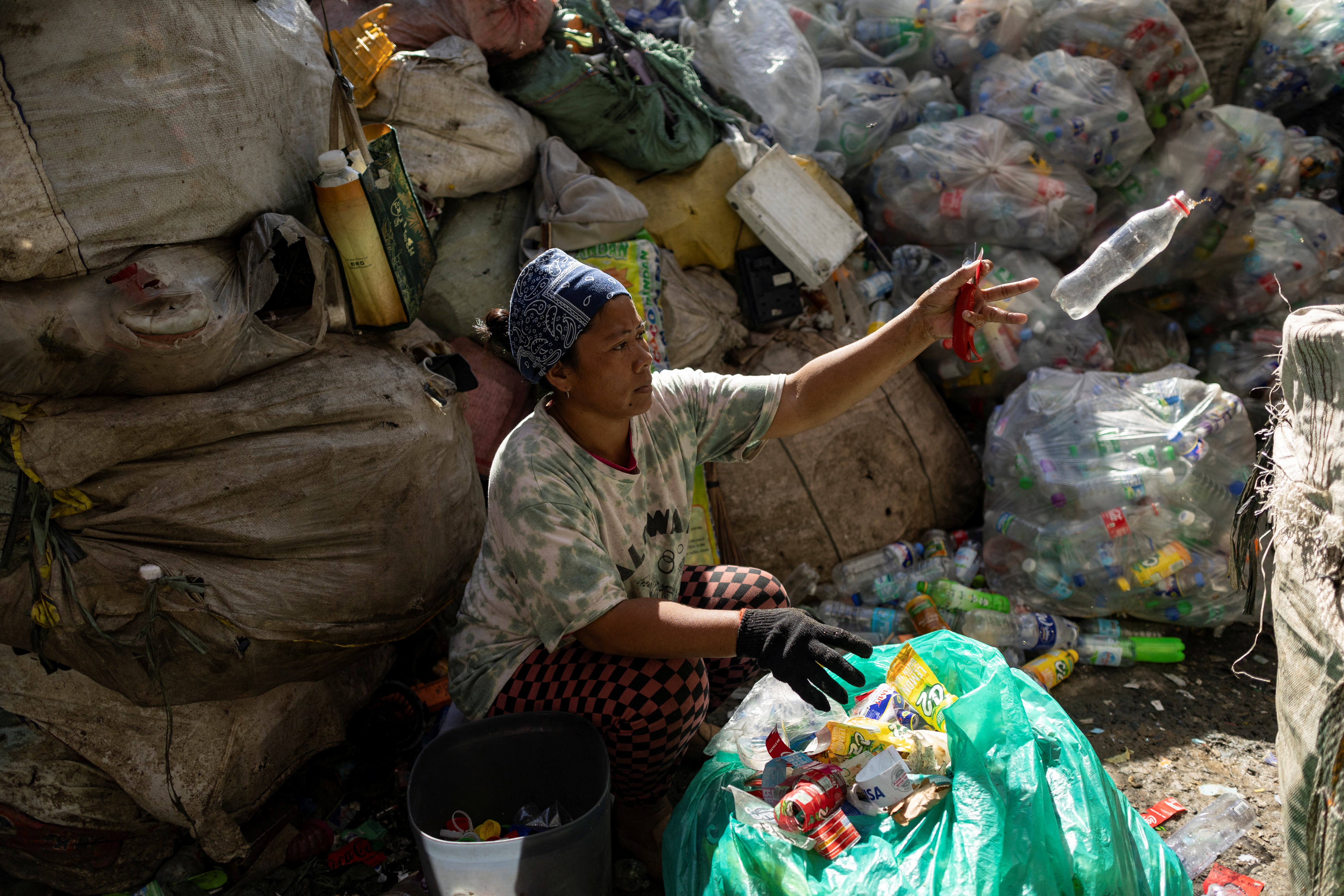 A woman sorts plastic bottles at a junk shop in Quezon City, Metro Manila, Philippines, November 27, 2024. REUTERS/Eloisa Lopez