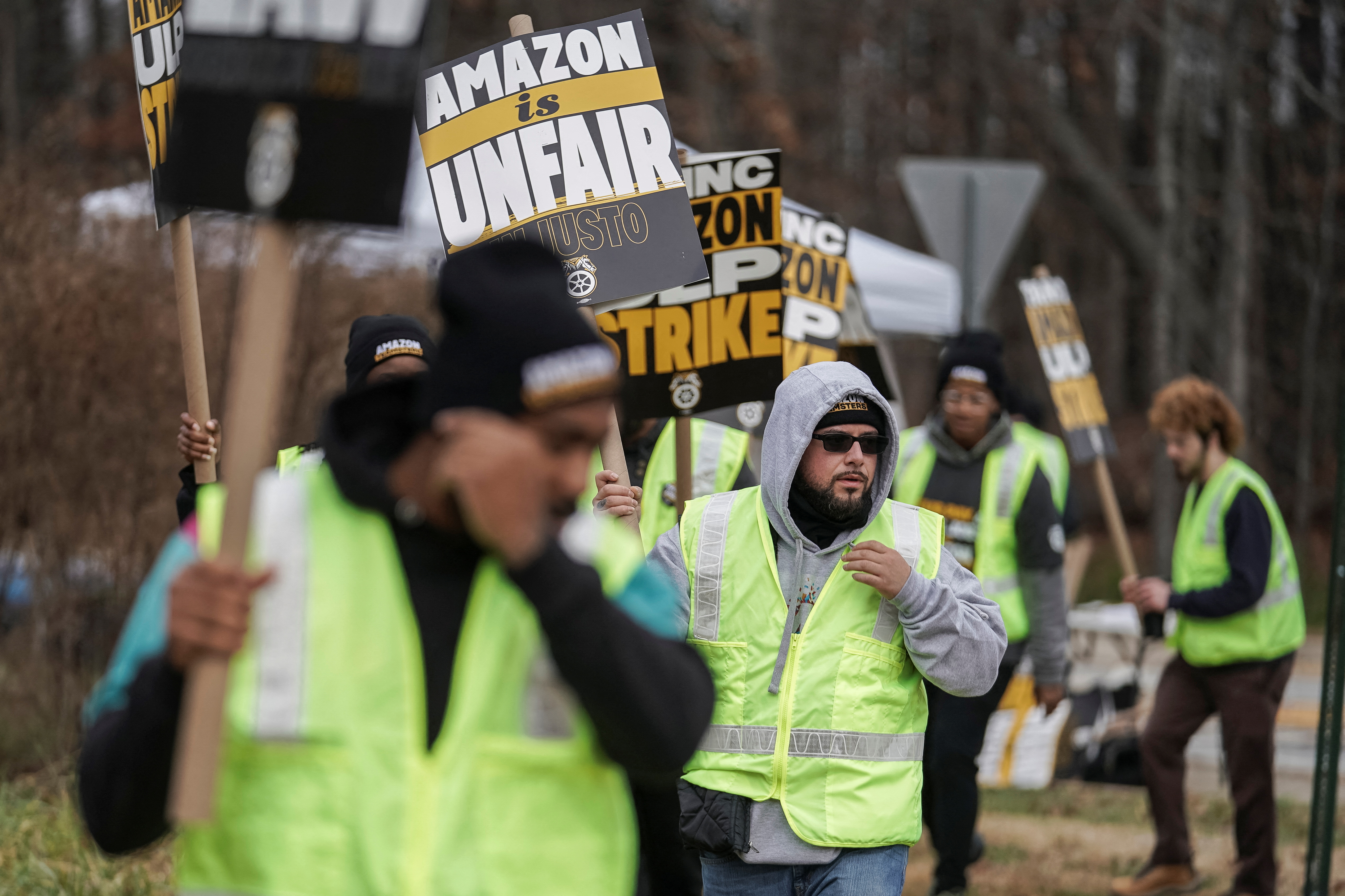 People hold signs and march during a strike by Teamsters union members at an Amazon facility in Alpharetta, Georgia, U.S. December 19, 2024. REUTERS/Elijah Nouvelage