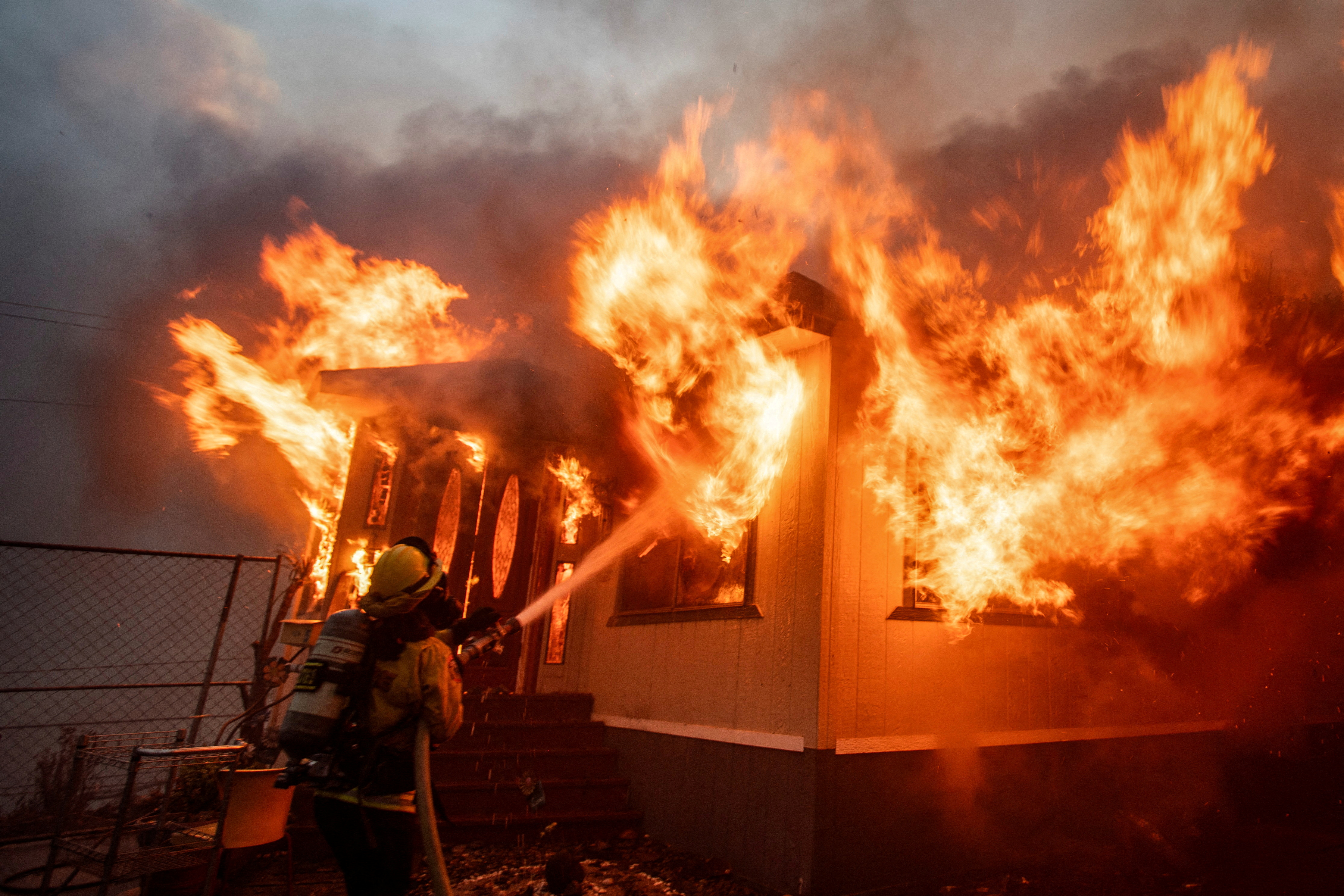 A firefighter battles the Palisades Fire as it burns during a windstorm on the west side of Los Angeles, California, U.S. January 7, 2025. REUTERS/Ringo Chiu