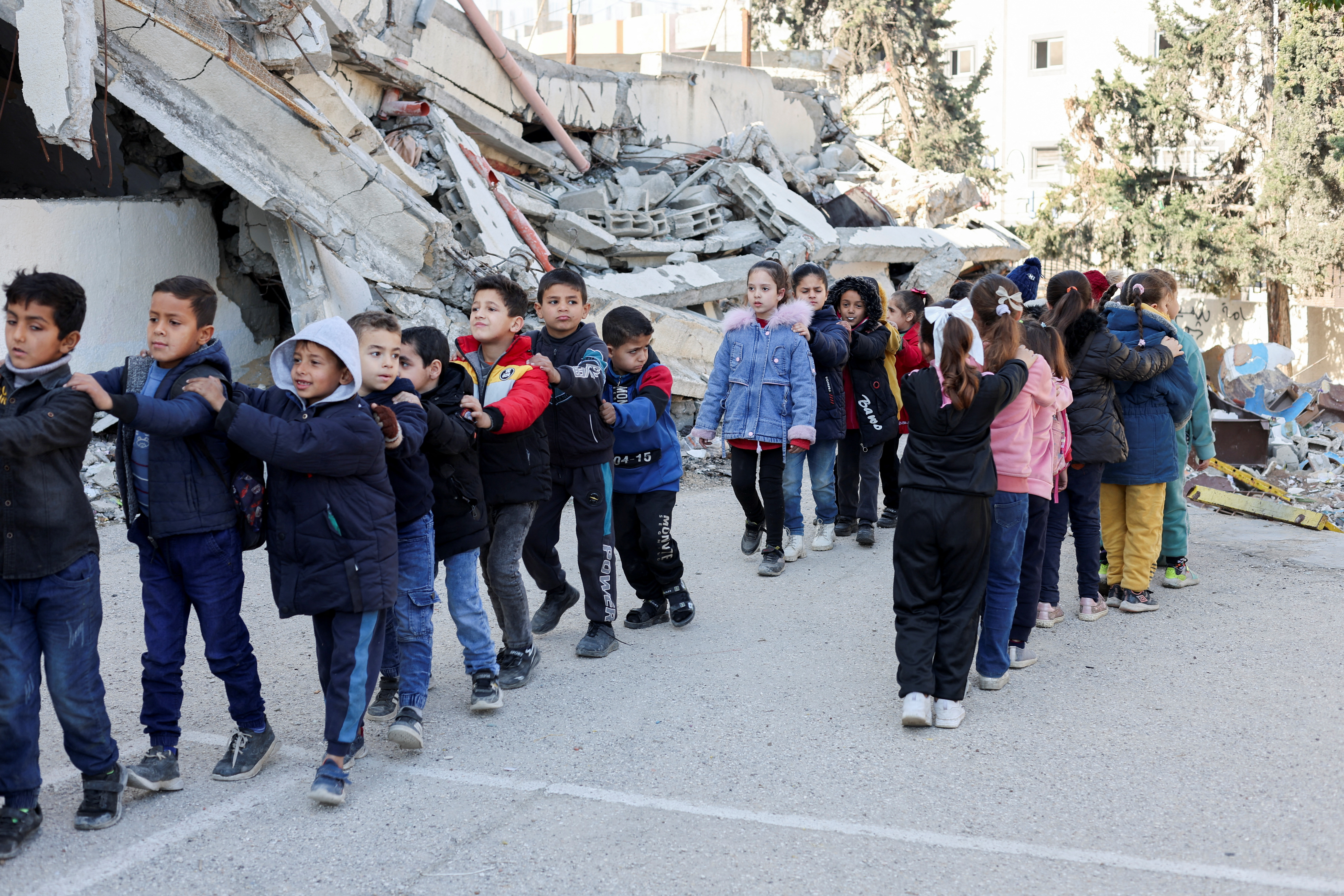 Palestinian children queue at a damaged school, amid a ceasefire between Israel and Hamas, in Gaza City, February 25, 2025. REUTERS/Dawoud Abu Alkas