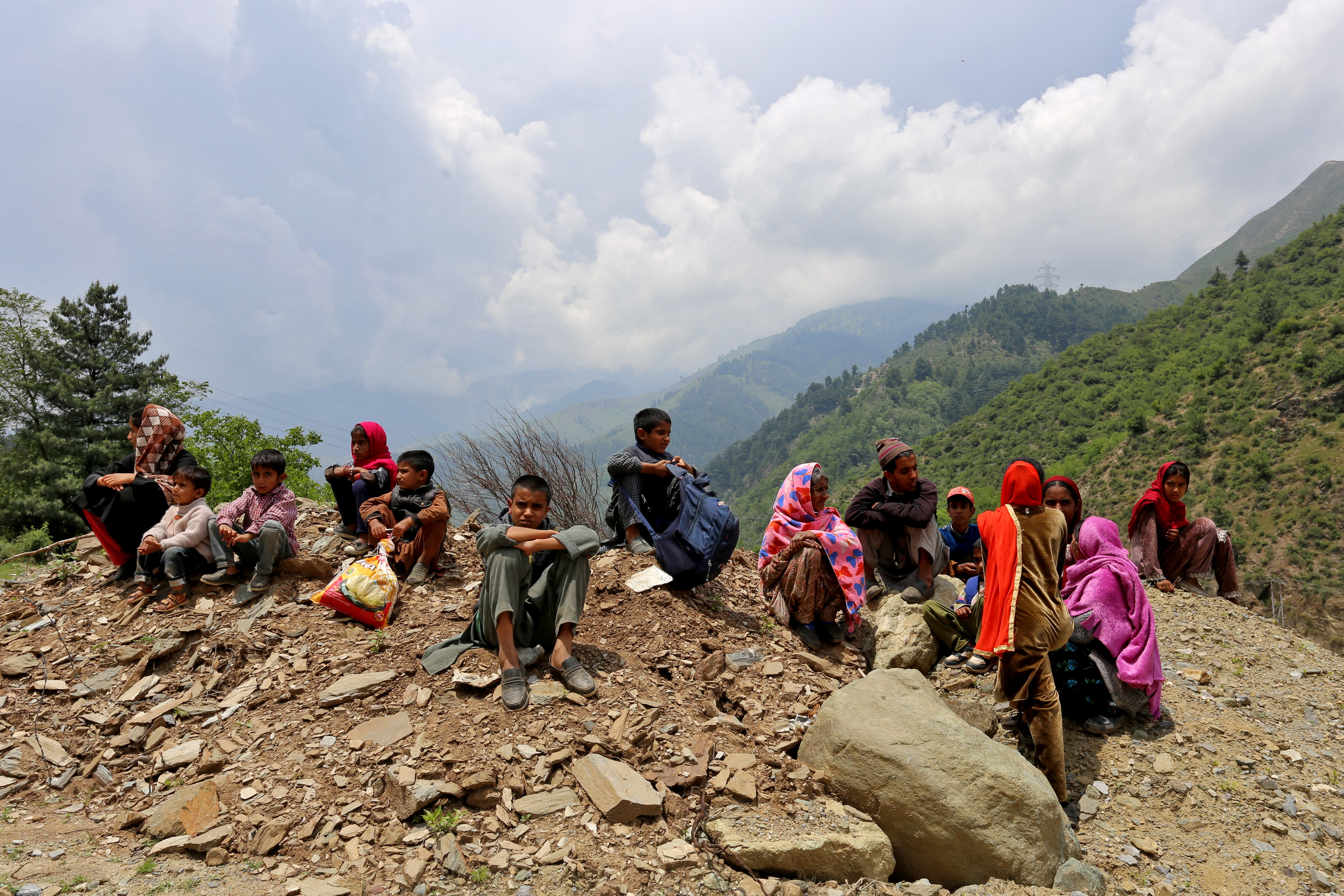 People who were evacuated from their homes near the Line of Control (LoC) between India and Pakistan following cross-border shelling, wait as authorities stopped them returning to their villages until the areas are cleared of unexploded ordnance, after the ceasefire between the two countries, in Gantamulla in Indian Kashmir's Baramulla district May 11, 2025. REUTERS/Stringer