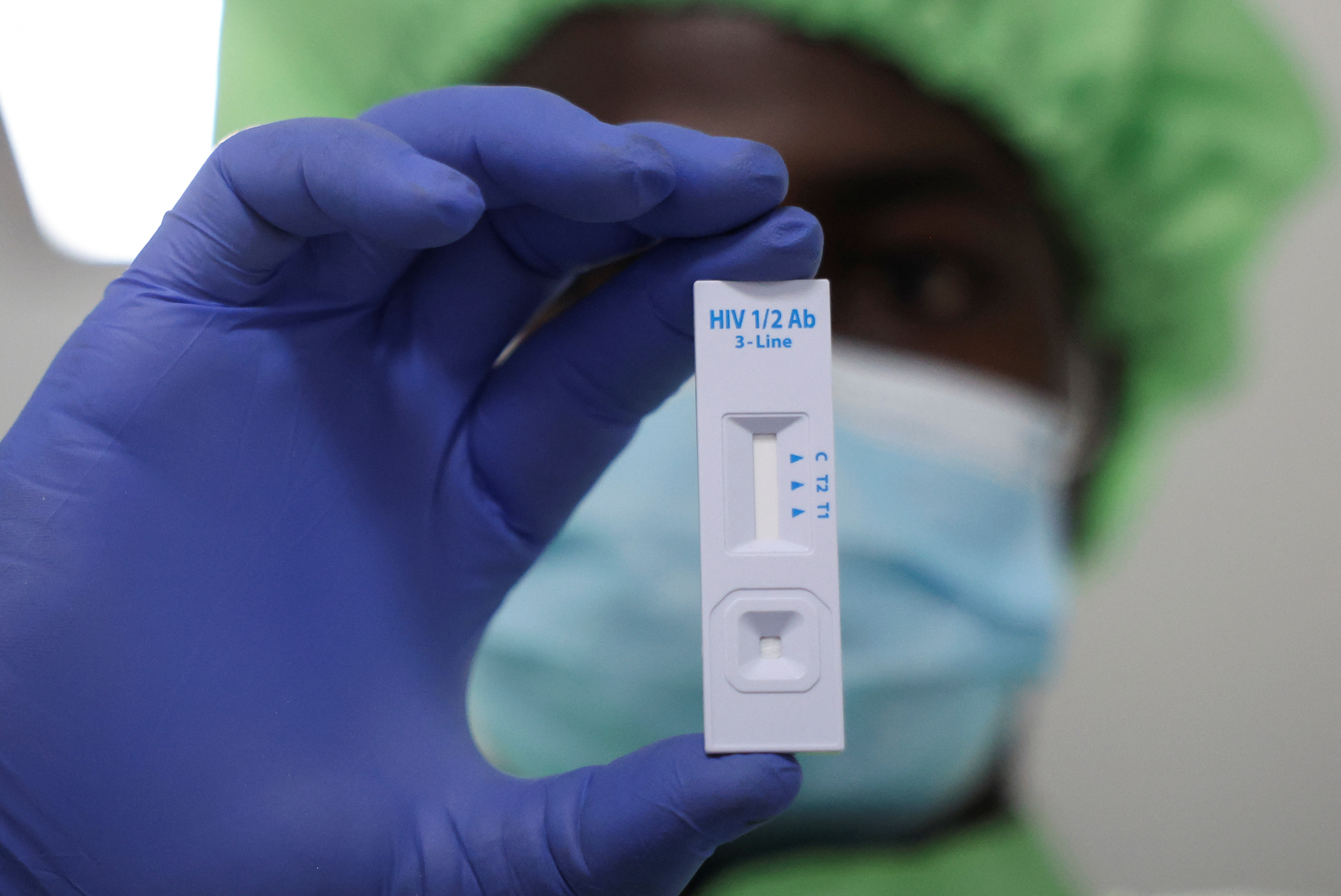 A worker displays a plastic test cassette for HIV 1/2 at Codix Bio production plant where HIV and Malaria test kits are locally produced, as it aims to fill the gap left by U.S. funding cuts to USAID, in Iperu-Remo in Ogun State, Nigeria, June 18, 2025. REUTERS/Sodiq Adelakun