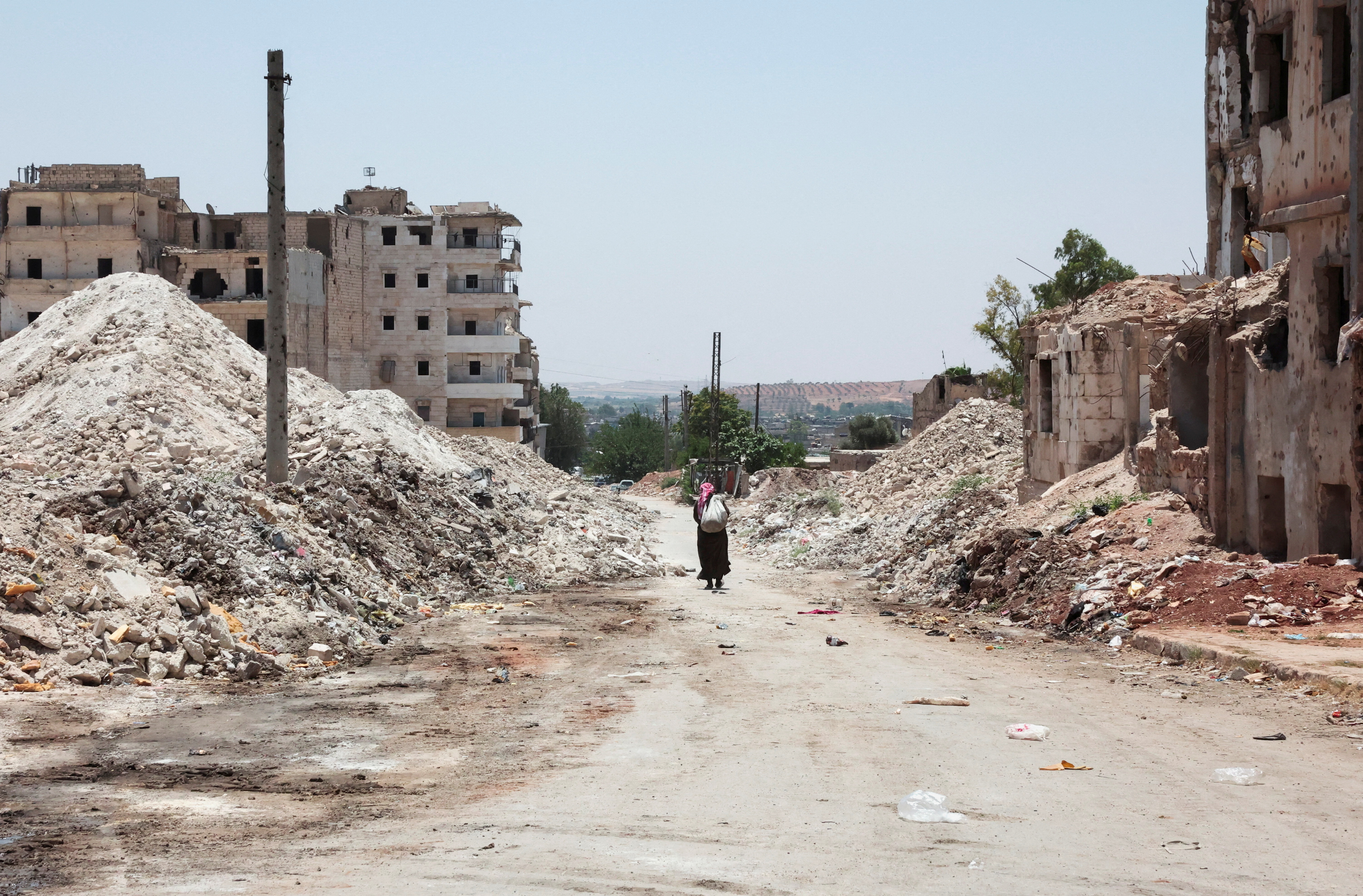 A man walks through the destruction in the city of Aleppo, Syria, June 23, 2025. REUTERS/Mahmoud Hassano