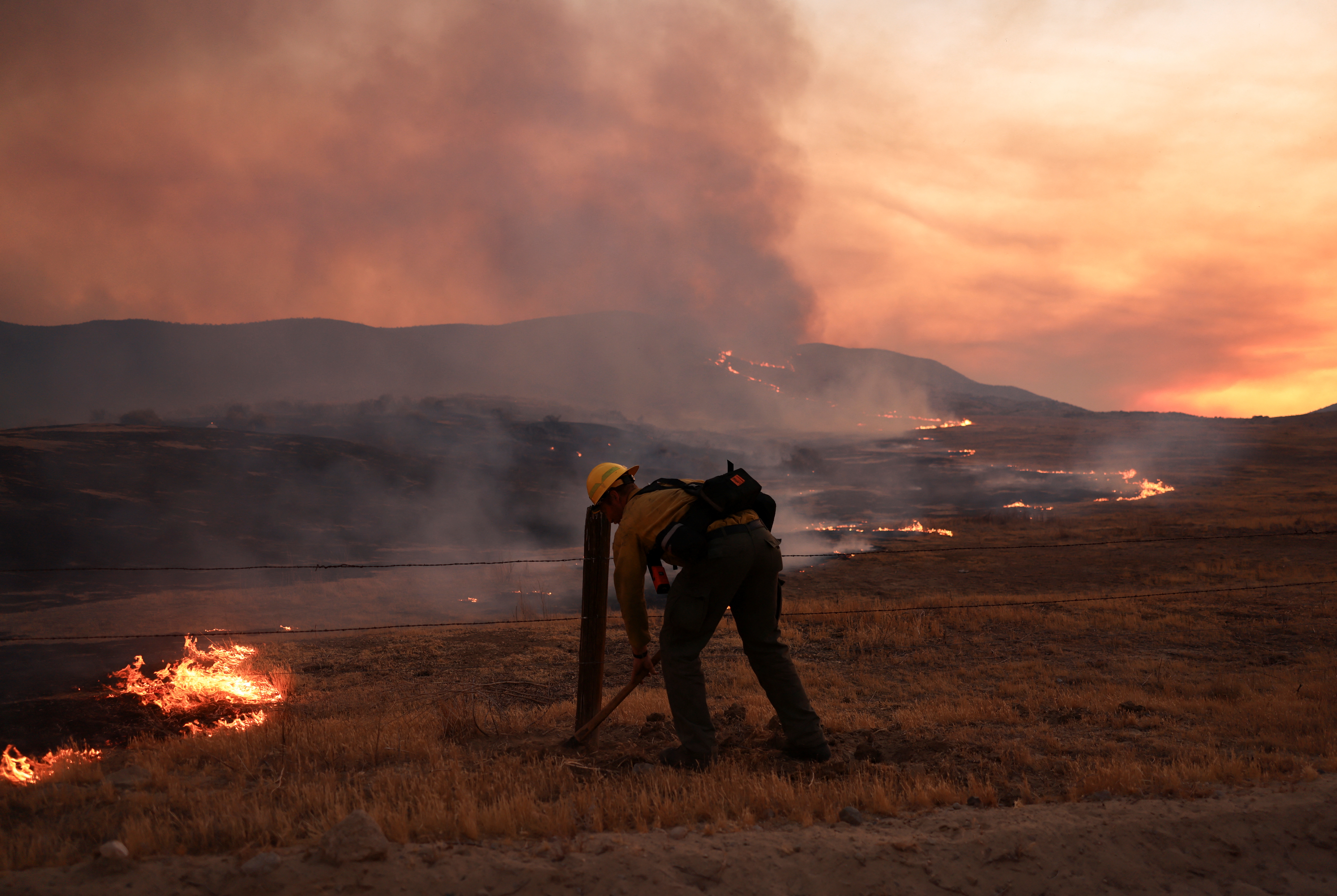 A firefighter works to tackle the Madre Fire near New Cuyama, California, U.S. July 3, 2025. REUTERS/David Swanson