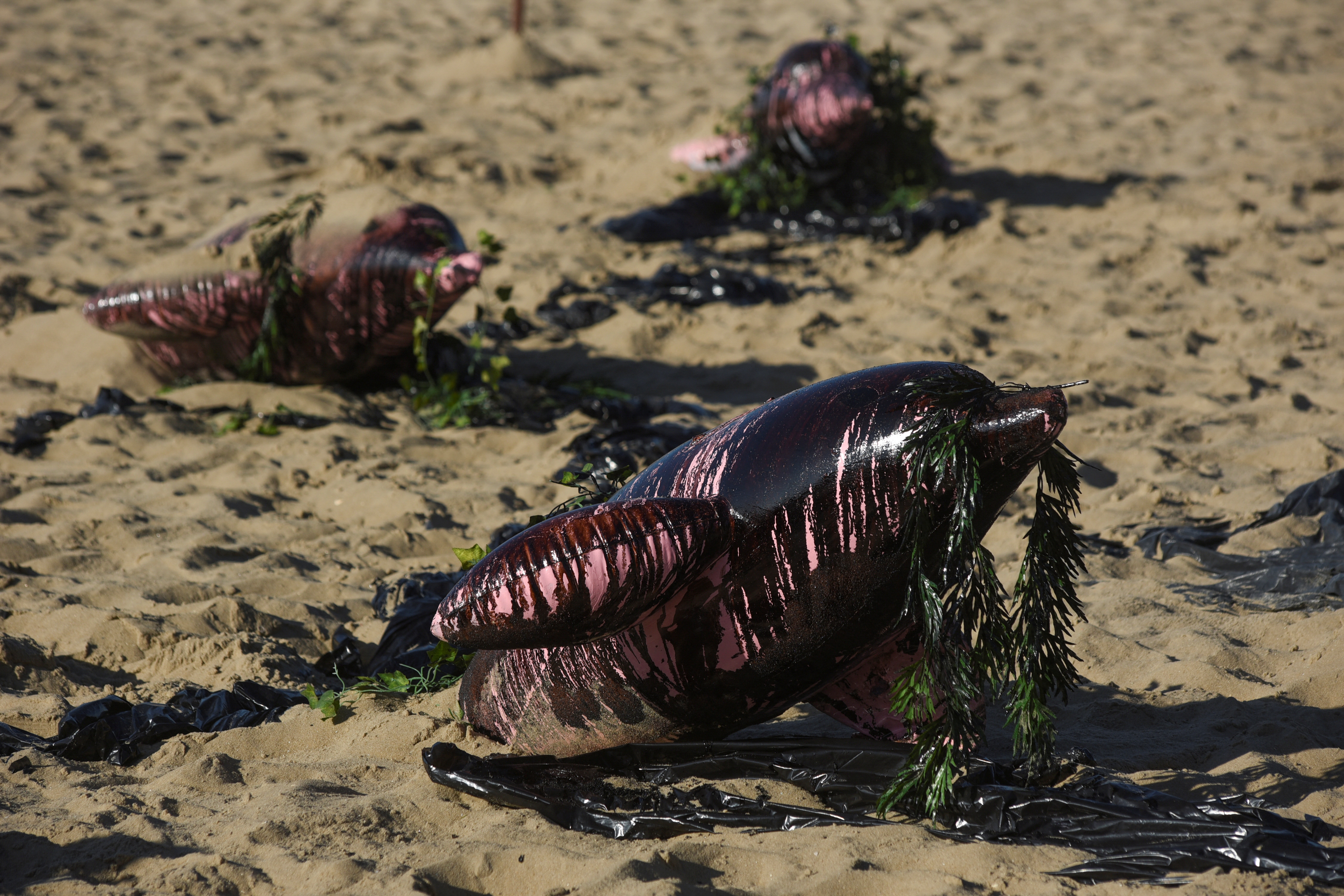 Inflatable figures depicting Amazonian dolphins covered in fake oil are seen during a protest against the expansion of oil exploration in the Amazon on Copacabana Beach in Rio de Janeiro, Brazil, July 5, 2025. REUTERS/Tita Barros