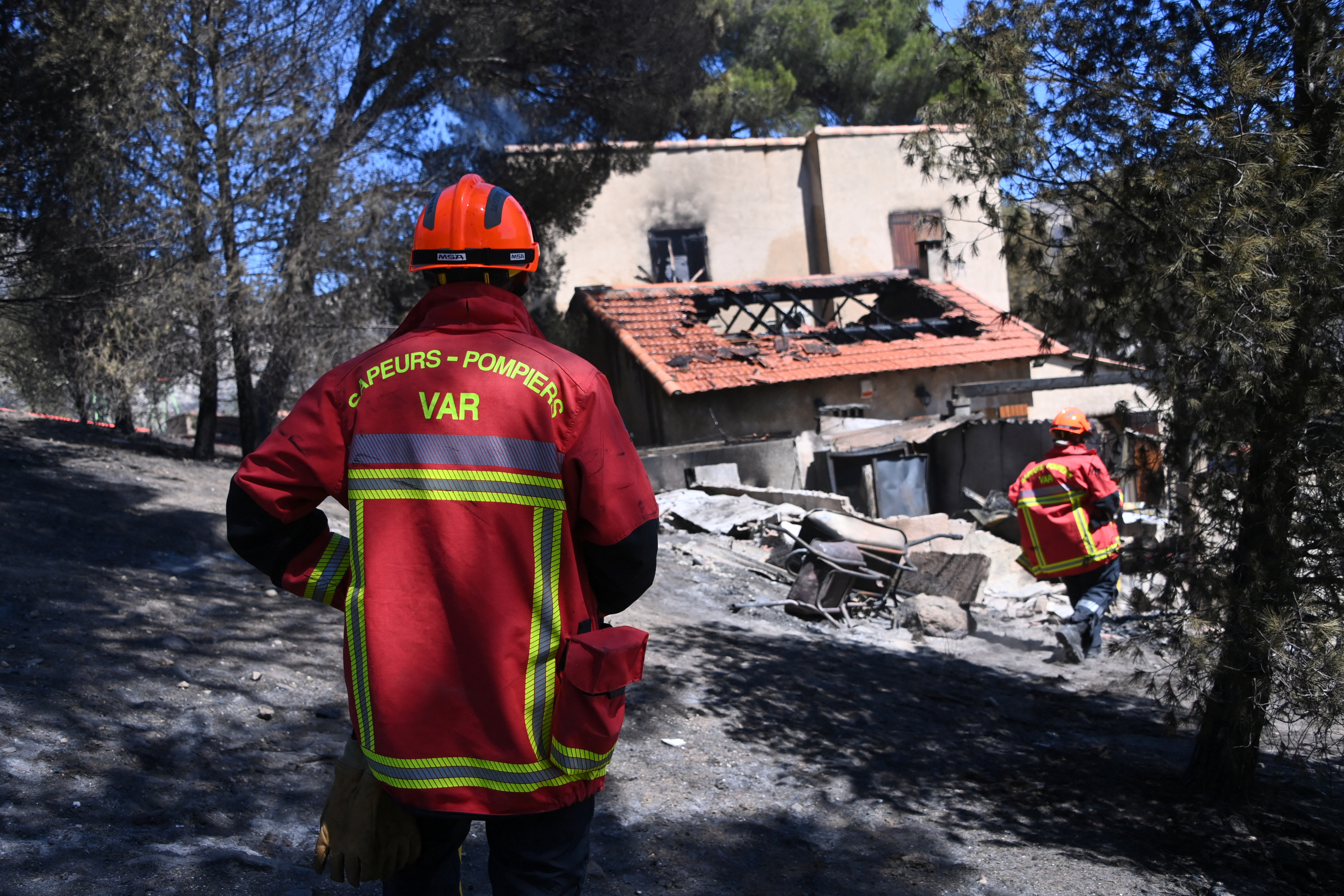 French firefighters check a house destroyed by a wildfire in the L'Estaque district of Marseille, southern France, July 9, 2025. REUTERS/Alexandre Dimou