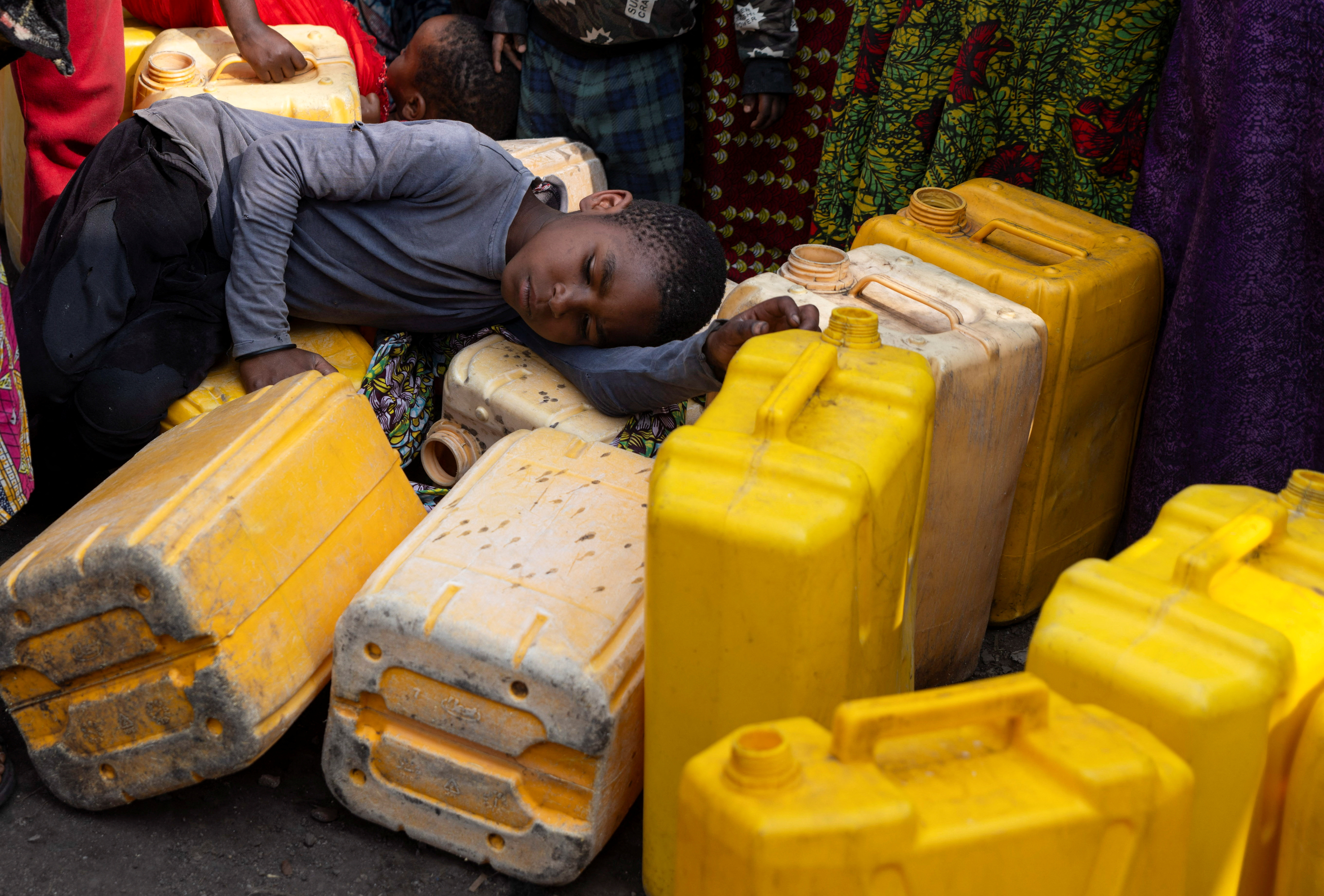 A child sleeps on plastic jerrycans, where incomplete water connections caused by USAID funding cuts have led to ongoing water shortages, in Goma, North Kivu province, Democratic Republic of Congo, June 16, 2025. REUTERS/Arlette Bashizi