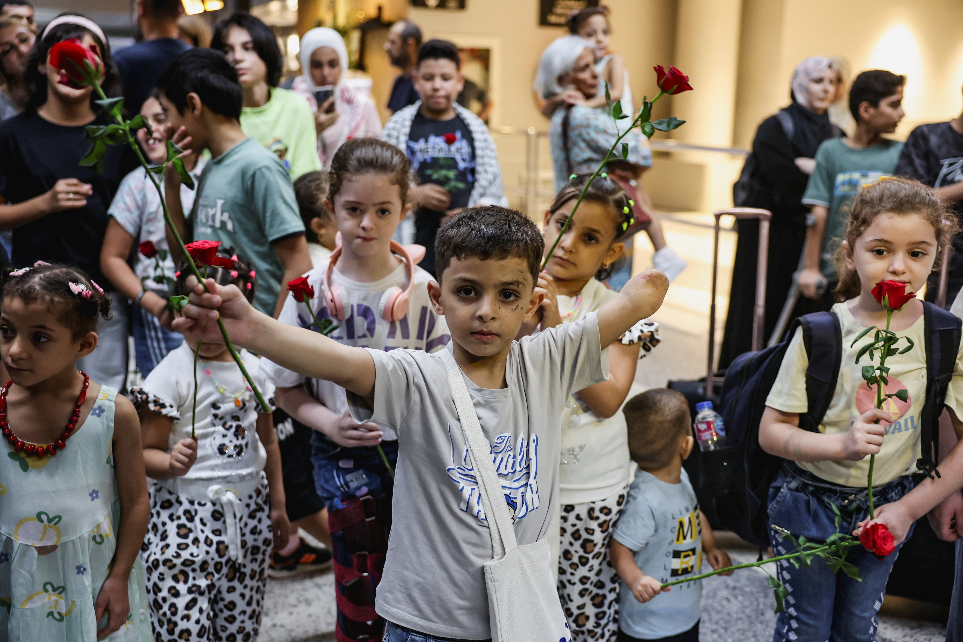 A child who lost an arm holds up a flower as six Gazan families with wounded children arrive at Beirut-Rafic Hariri International Airport for medical treatment, in Beirut, Lebanon September 2, 2025. REUTERS/Mohamed Azakir