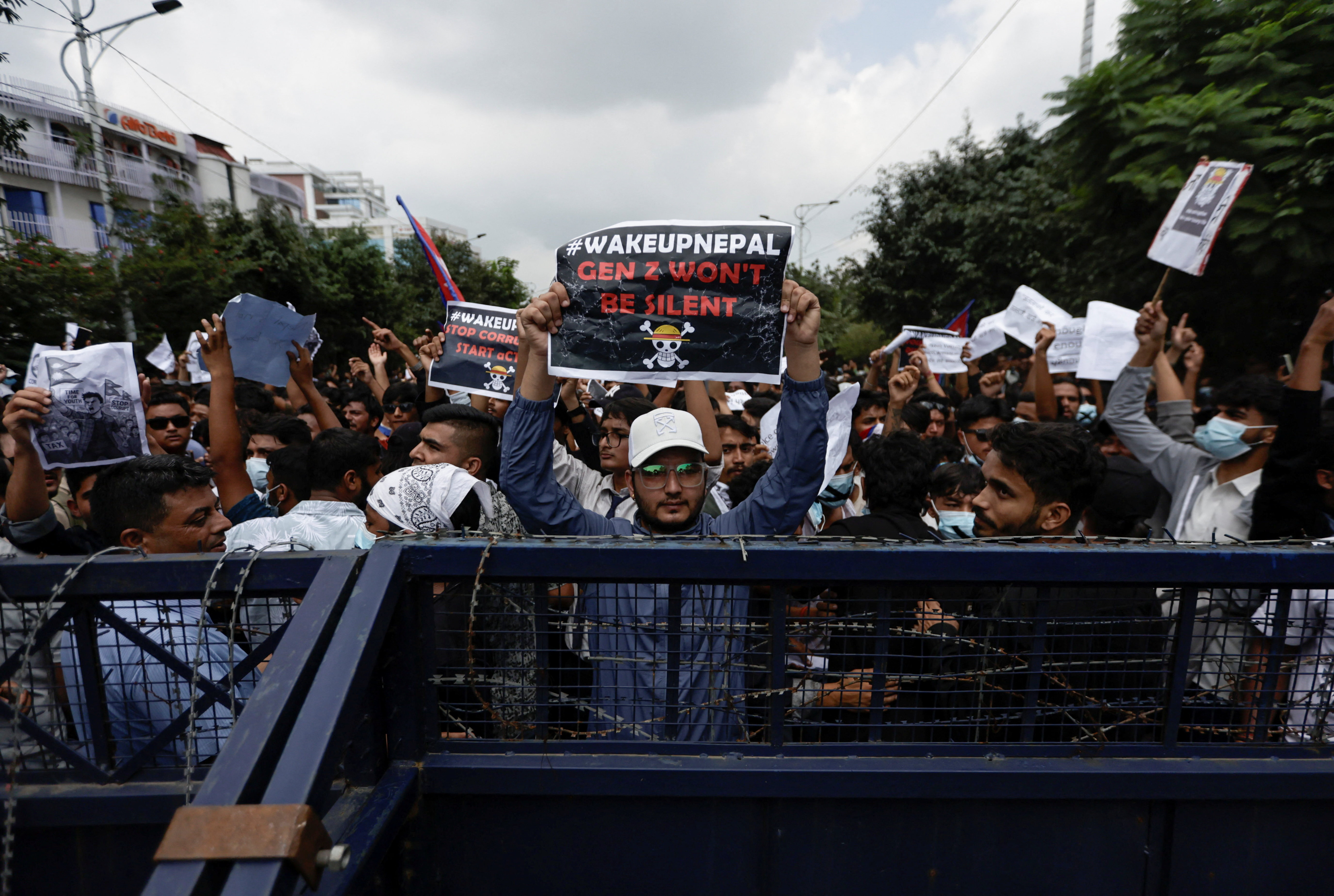 Demonstrators holding placards stand behind barricades during a protest against corruption and the government's decision to block several social media platforms, in Kathmandu, Nepal September 8, 2025. REUTERS/Navesh Chitrakar