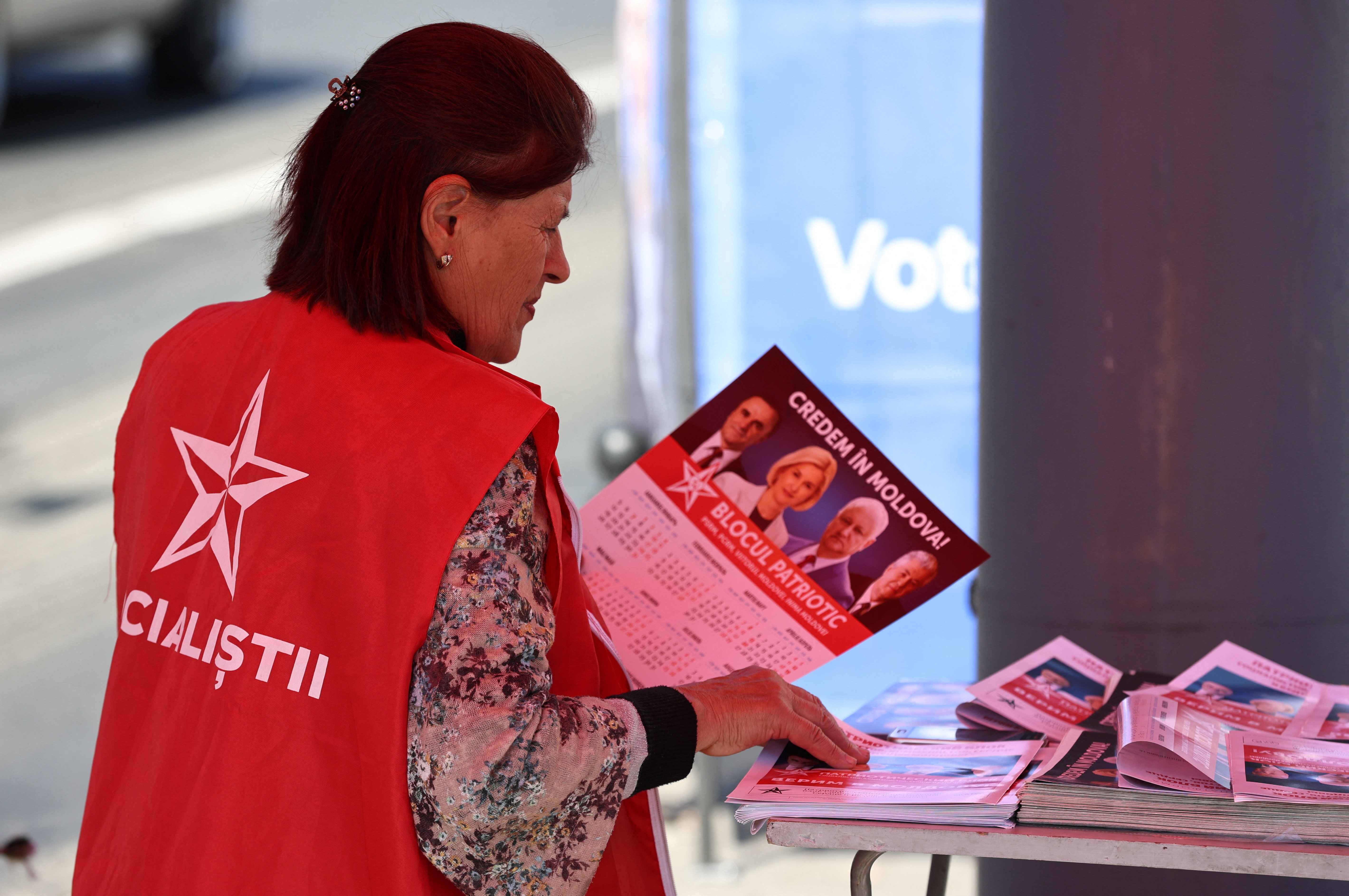 A participant of the Patriotic Electoral Bloc's campaign sorts leaflets while agitating voters in a street ahead of Moldova's upcoming parliamentary elections in Chisinau, Moldova, September 21, 2025. REUTERS/Vladislav Culiomza