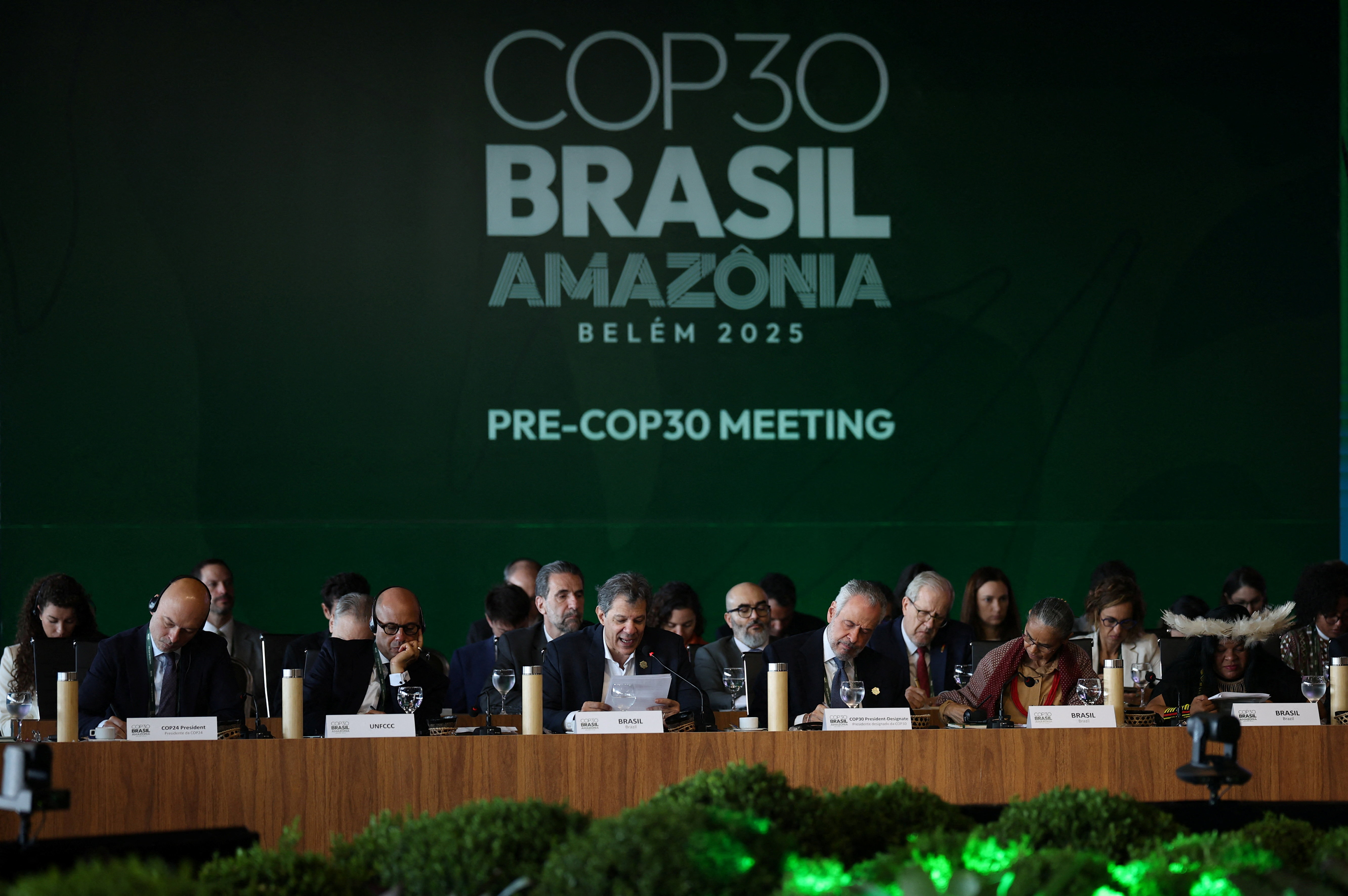 Brazil's Finance Minister Fernando Haddad speaks next to Simon Stiell, Executive Secretary of UN Climate Change (UNFCCC), and Brazil's COP30 President Andre Correa do Lago during the ministerial preparatory meeting (Pre-COP30), ahead of the COP30 Climate Summit, in Brasilia, Brazil October 13, 2025. REUTERS/Mateus Bonomi