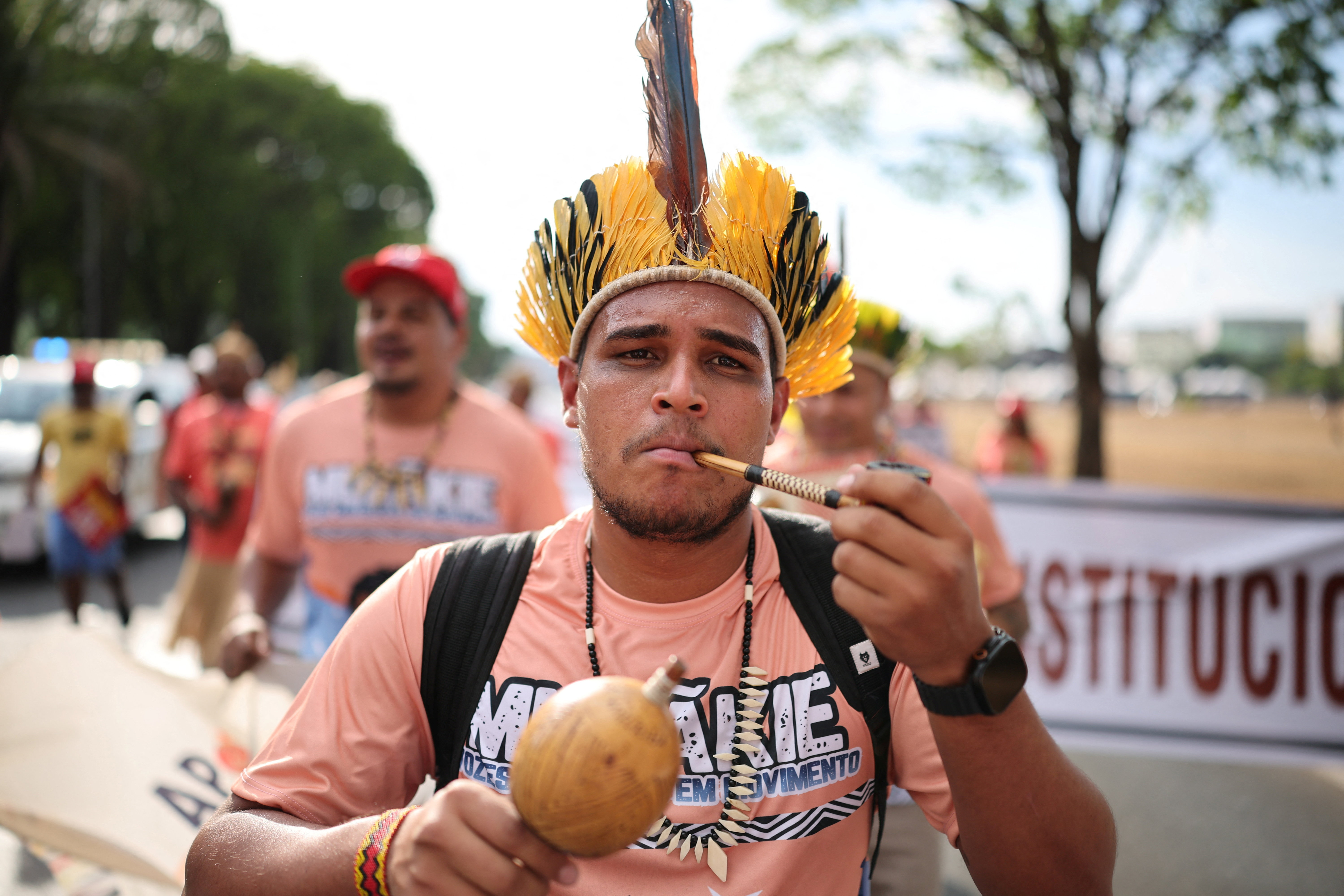 An Indigenous man smokes during a protest calling for the recognition of 104 territories and urging Brazil's President Luiz Inacio Lula da Silva to complete land demarcations, ahead of the COP30 Climate Summit, in Brasilia, Brazil October 13, 2025. REUTERS/Mateus Bonomi
