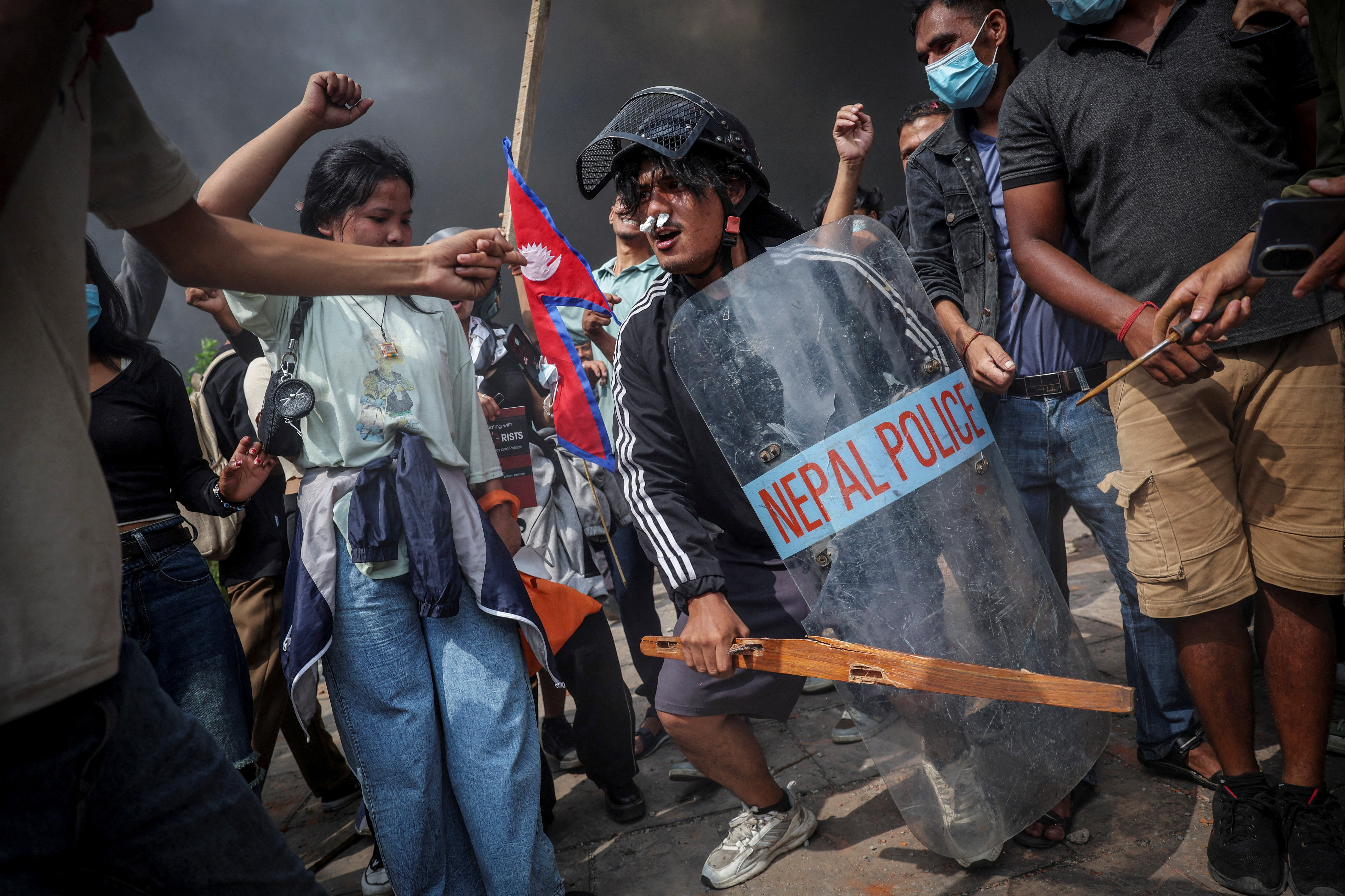 Demonstrators celebrate as smoke rises from a fire during anti-corruption protests in Kathmandu, Nepal, September 9, 2025. REUTERS/Adnan Abidi