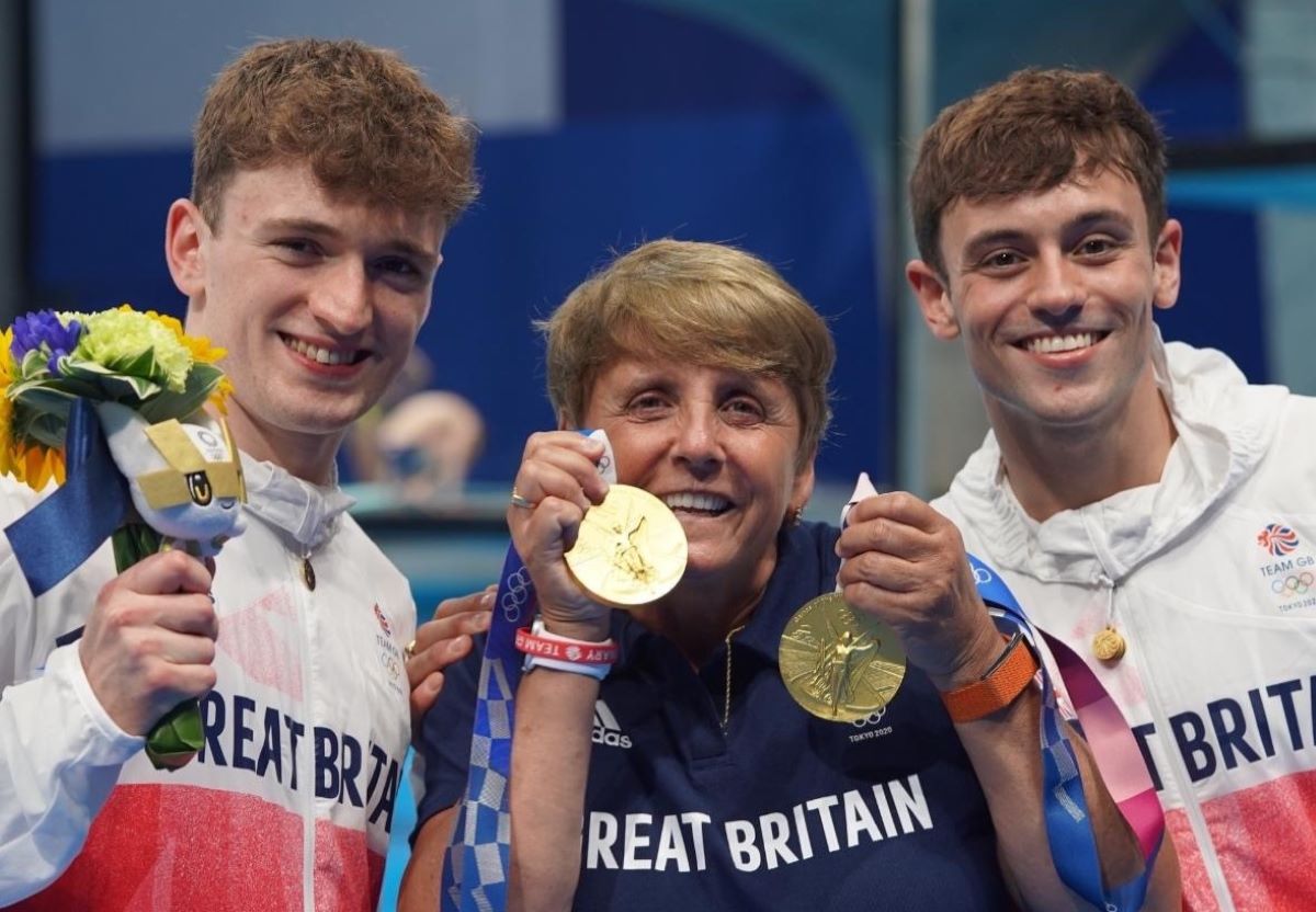 British diving champions Tom Daley and Matthew Lee with their coach Jane Figueirdo show off their gold medals at the Tokyo Games in 2021.  Thomson Reuters Foundation/Handout via Female Coaching Network