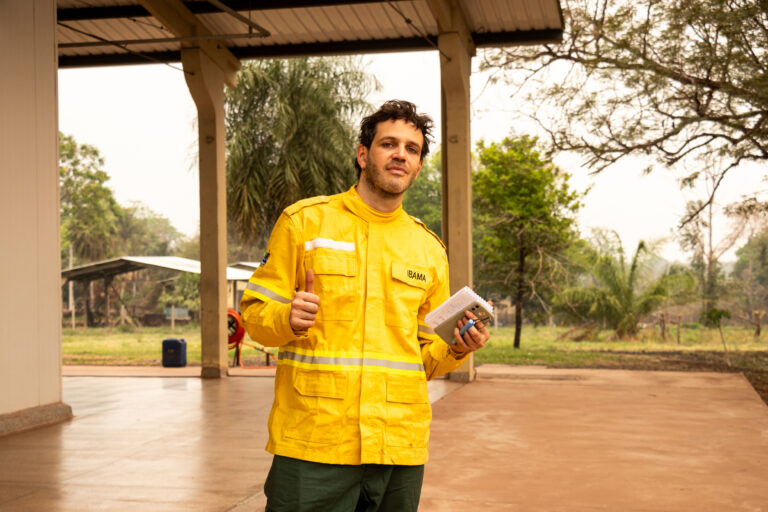 Context reporter Andre Cabette Fabio poses for a photo in a firefighters uniform during a reporting trip in Corumbá, Brazil, September, 11, 2024. Thomson Reuters Foundation/Henrique Kawaminami
