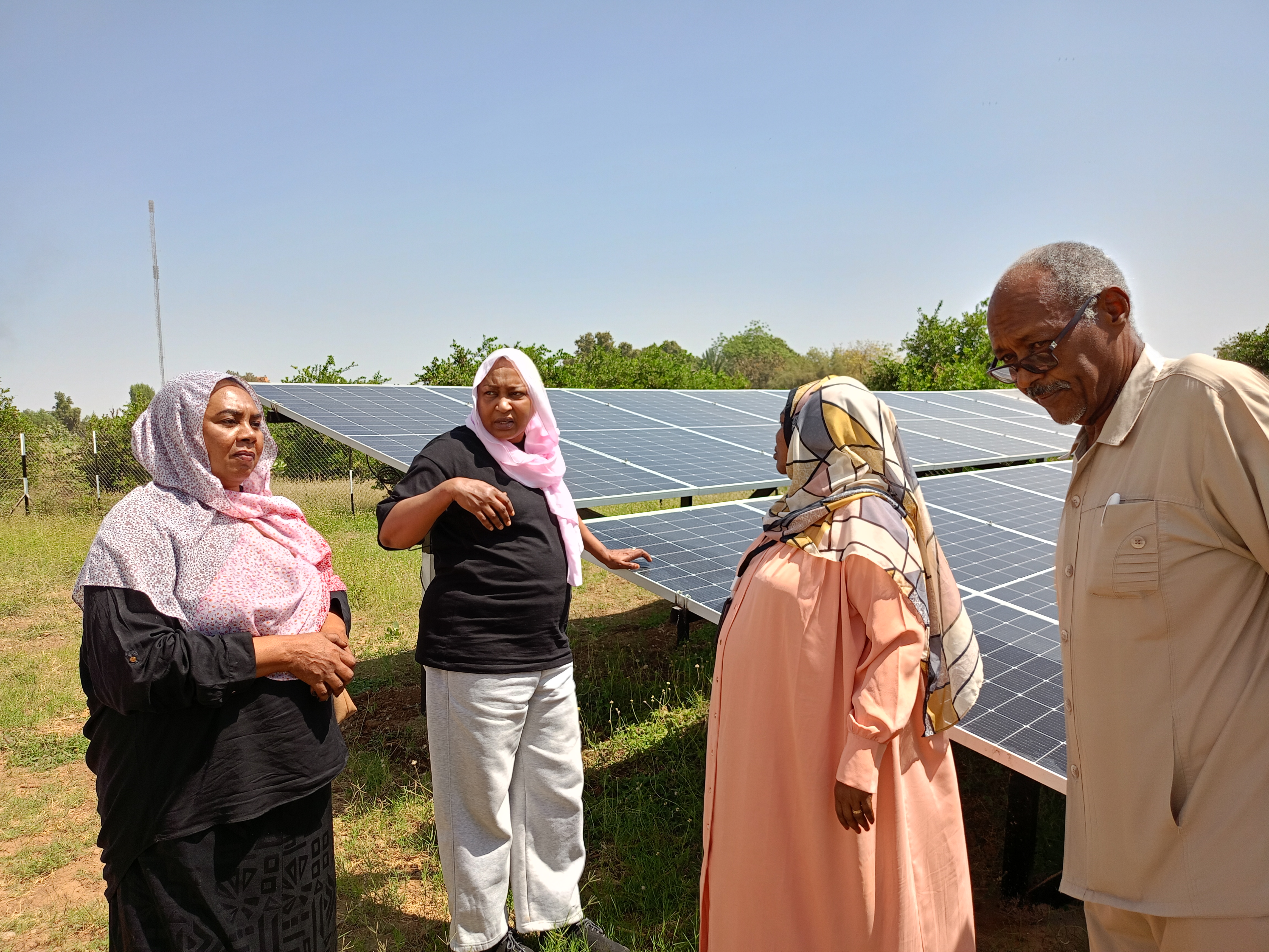 Muna Eltahir, country director for Practical Action in Sudan, talks to community members in Sudan about solar panels which have been installed to help them pump water to irrigate their crops in this undated photo. Practical Action/Handout via Thomson Reuters Foundation